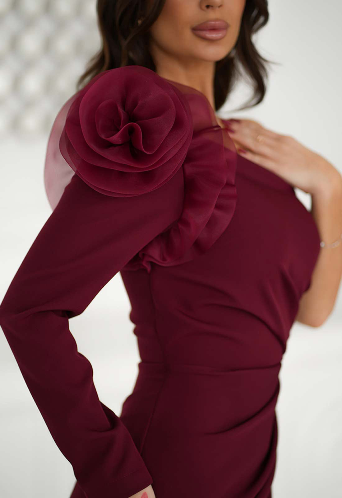 Maroon dress with floral detailing on a plain background