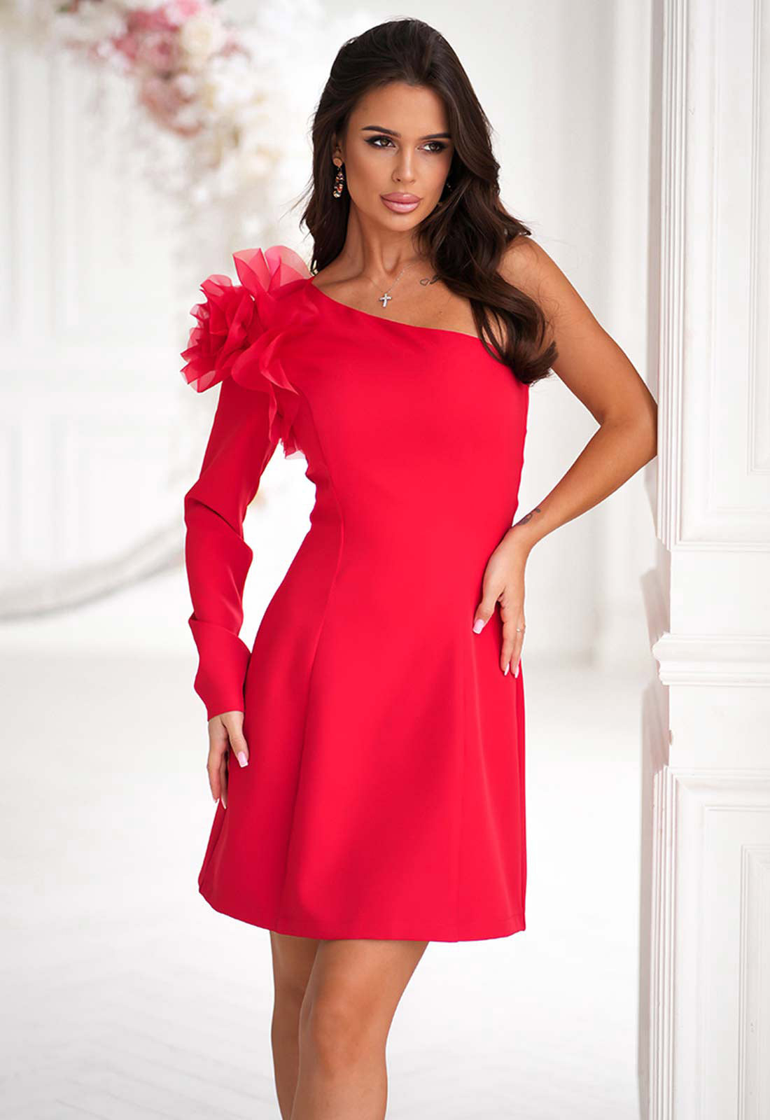 Woman wearing a red dress with floral details against a white background