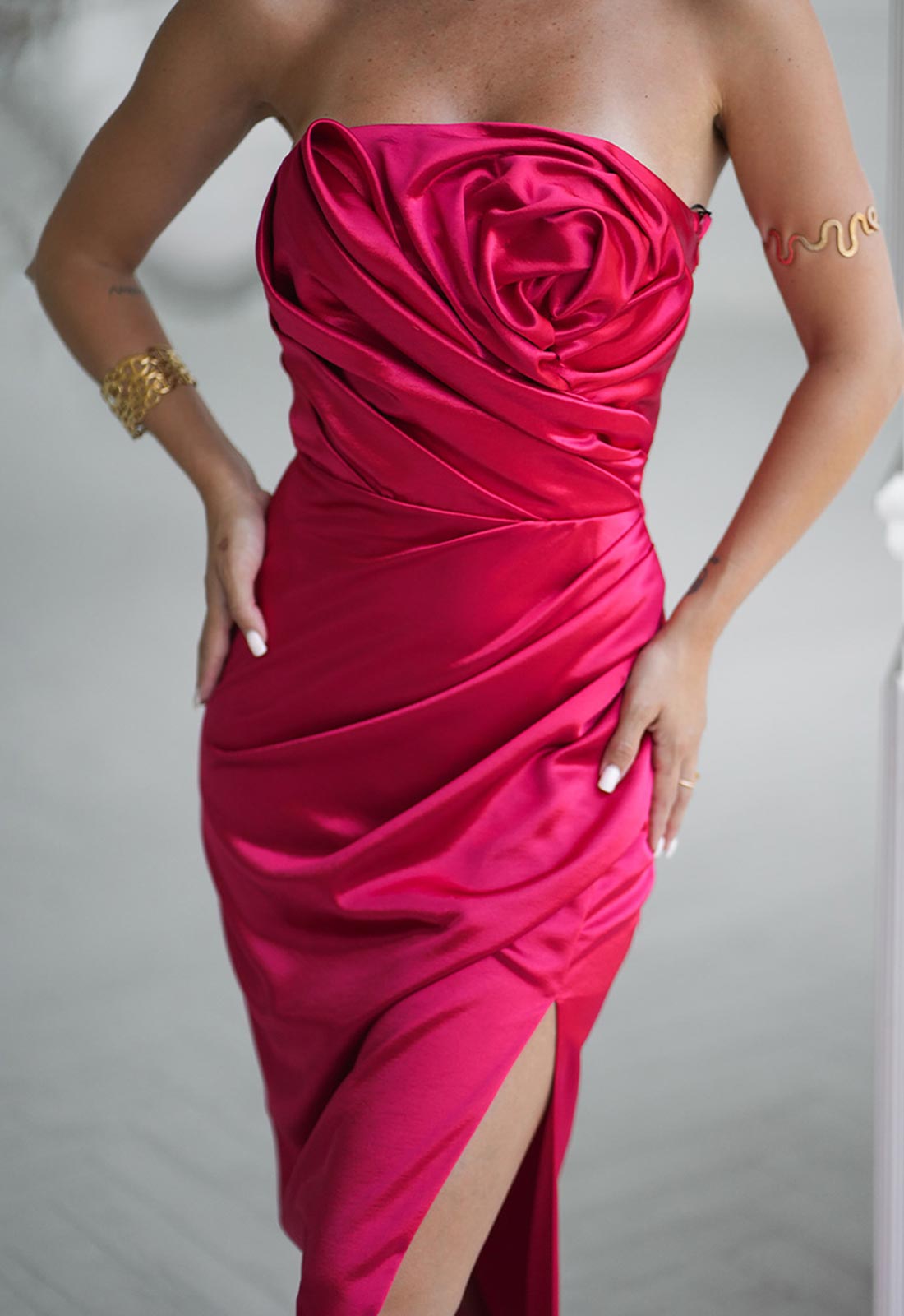 Pink strapless dress with a ruched design on a plain background