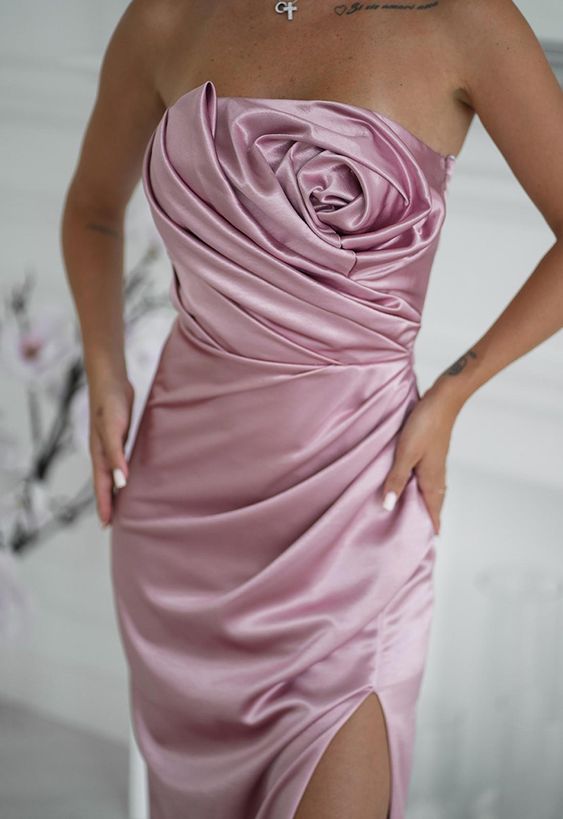 Pink strapless dress with a large ruffled rose design on a plain background