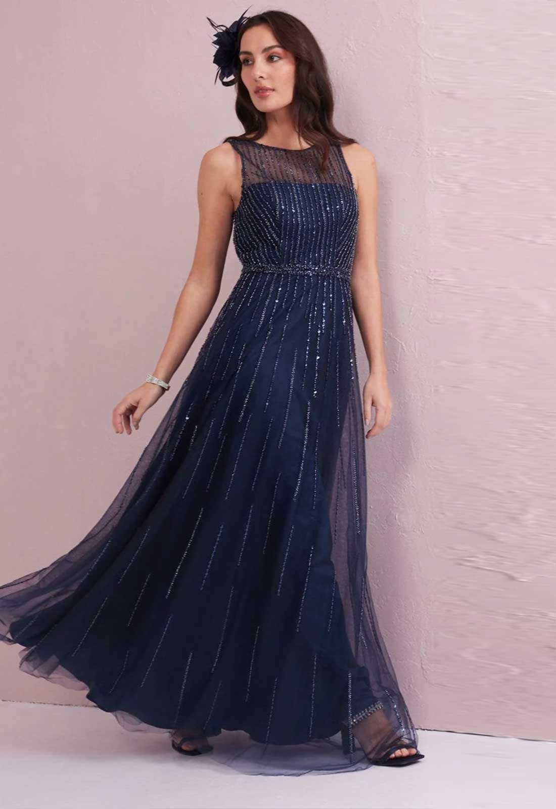 Woman wearing a navy blue evening gown with a textured background