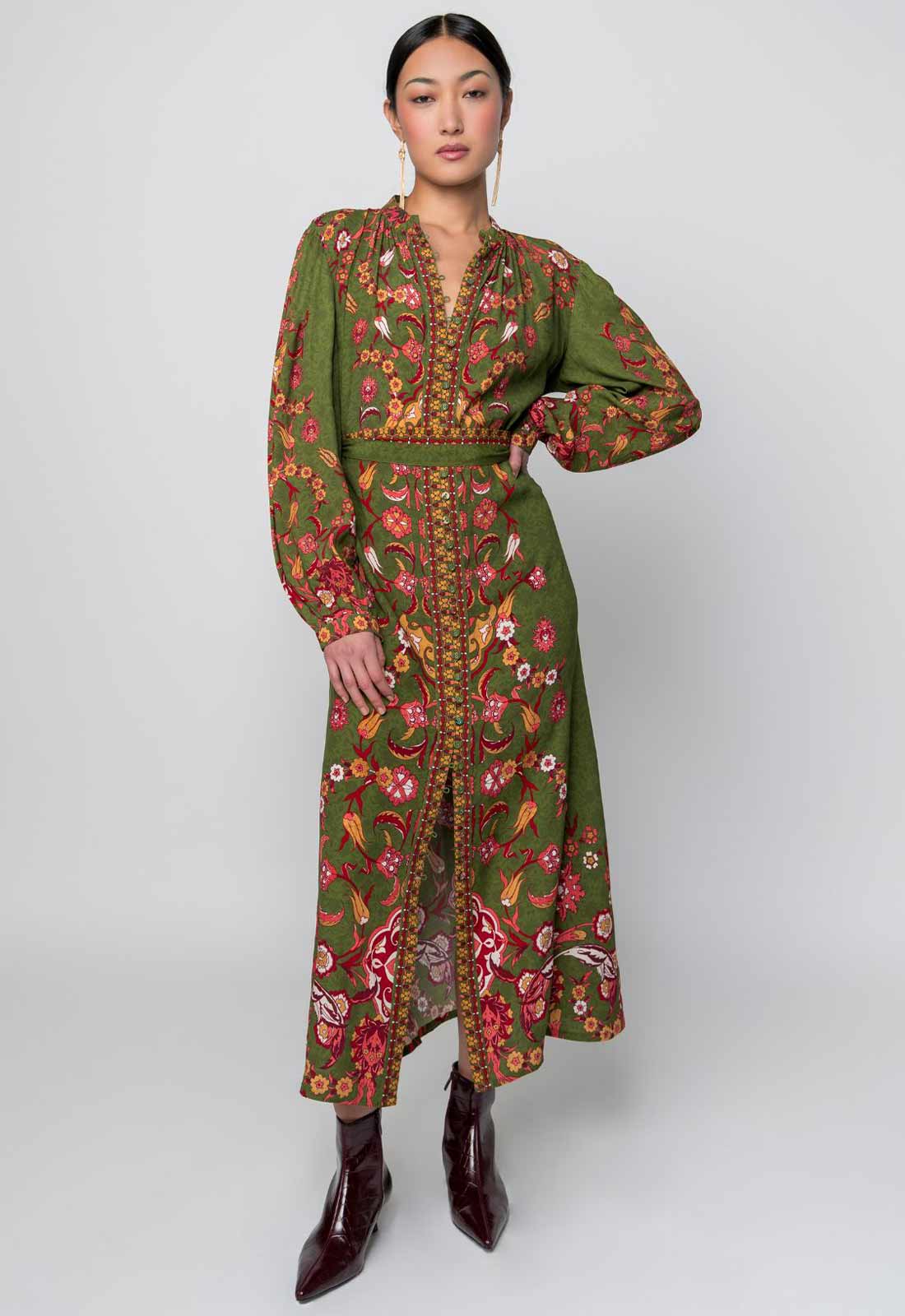 Woman wearing a long, floral embroidered dress on a white background