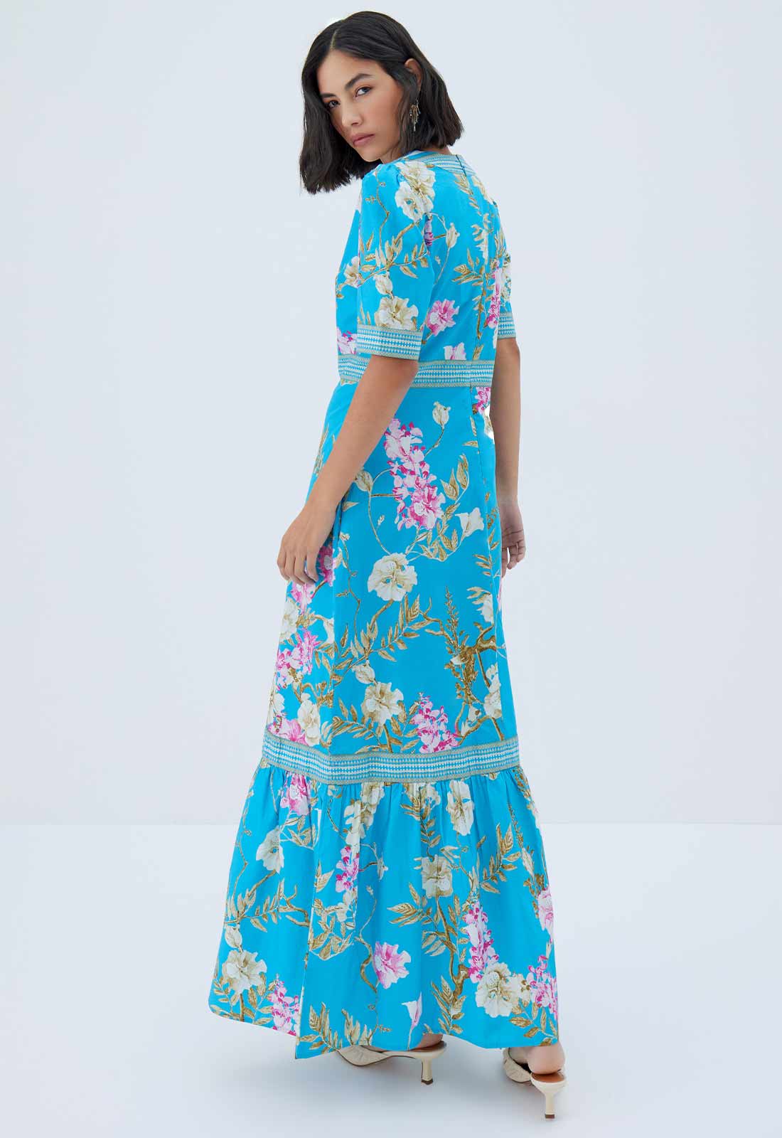 Woman wearing a blue floral dress on a white background