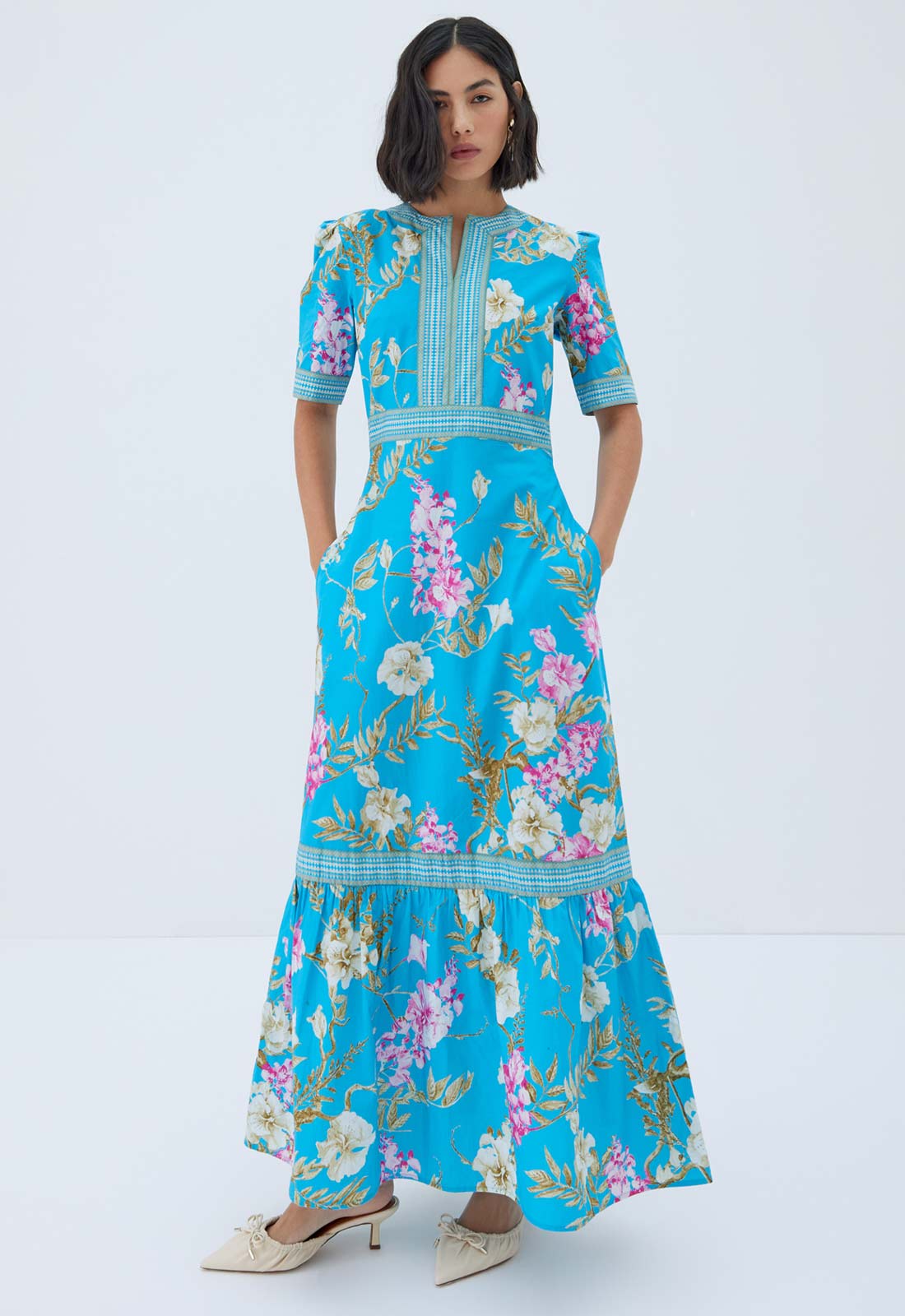 Woman wearing a blue floral dress on a white background