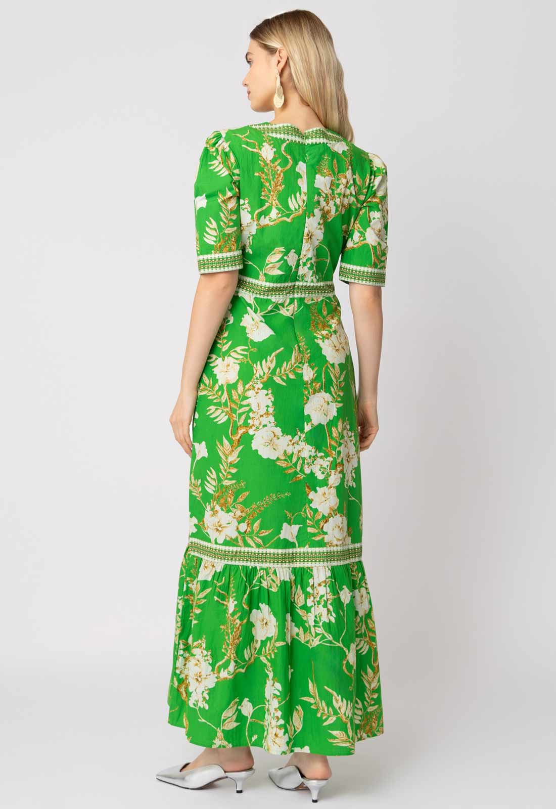 Woman wearing a green floral dress on a white background