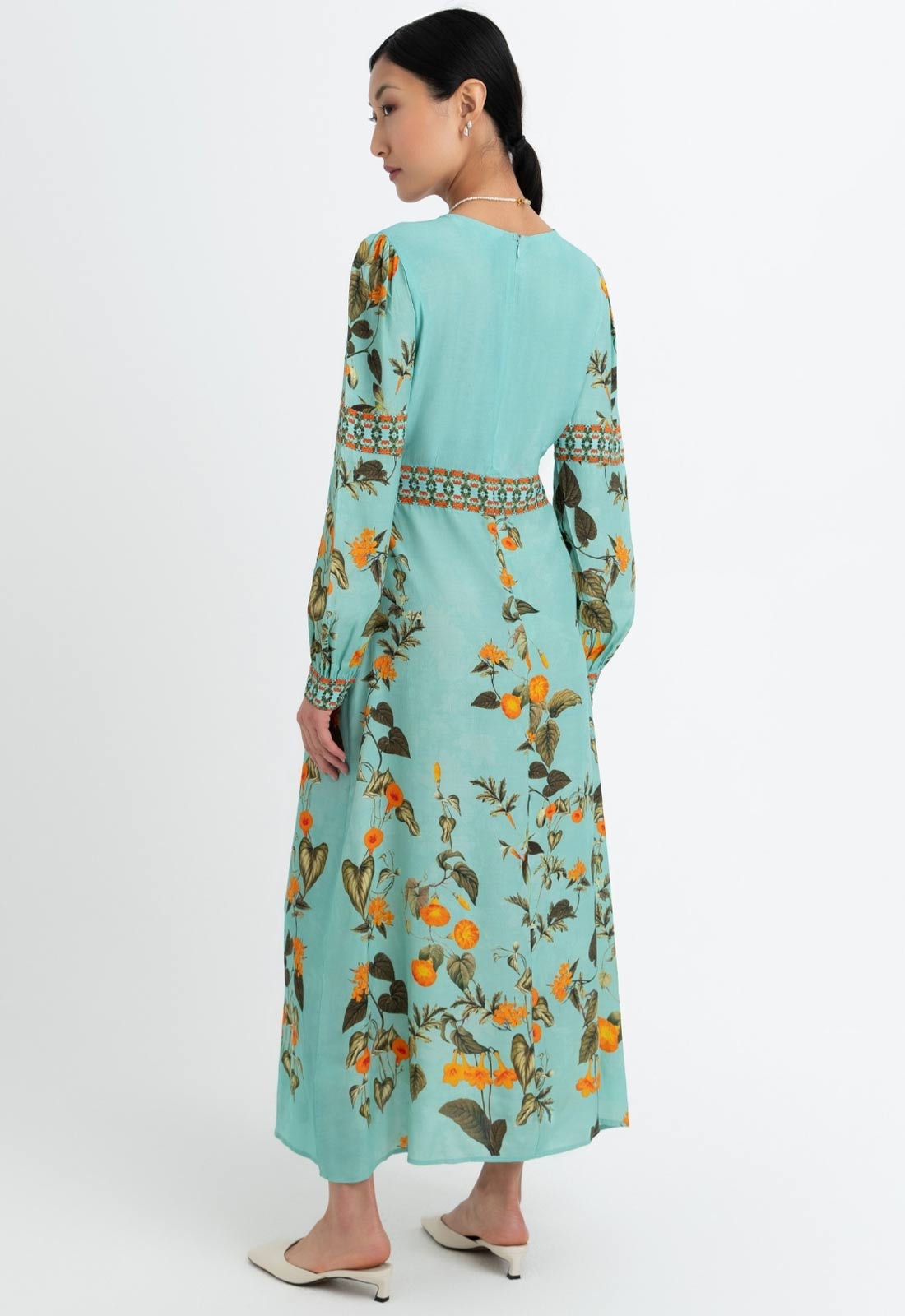 Woman wearing a light blue floral dress on a white background