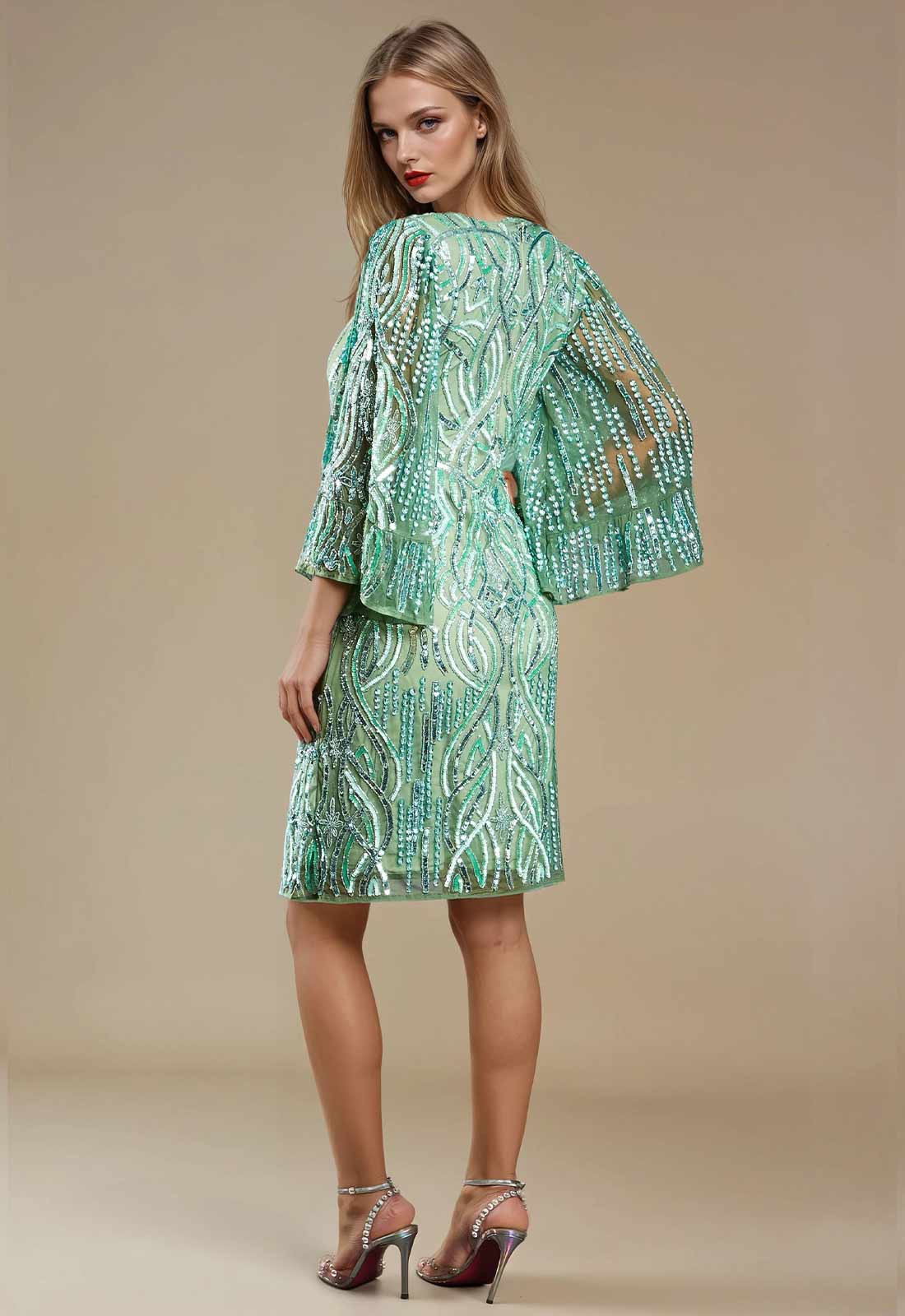 Woman wearing a green sequin dress and jacket on a beige background