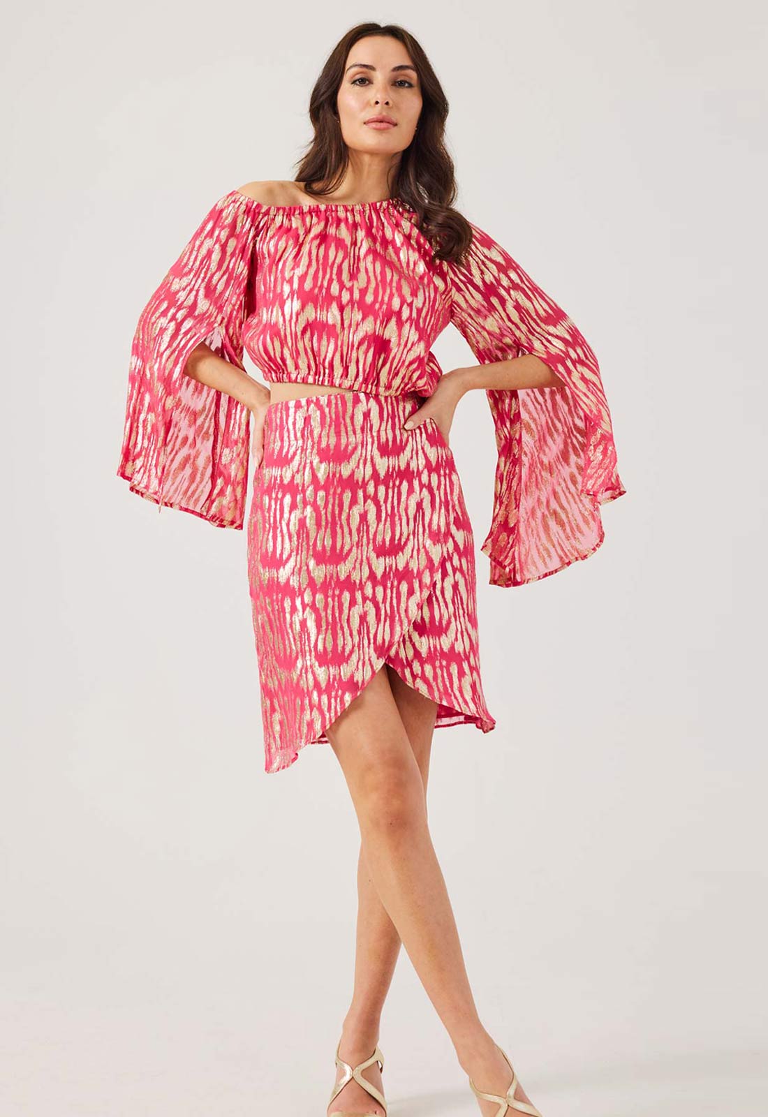 Woman wearing a pink and white patterned dress on a white background