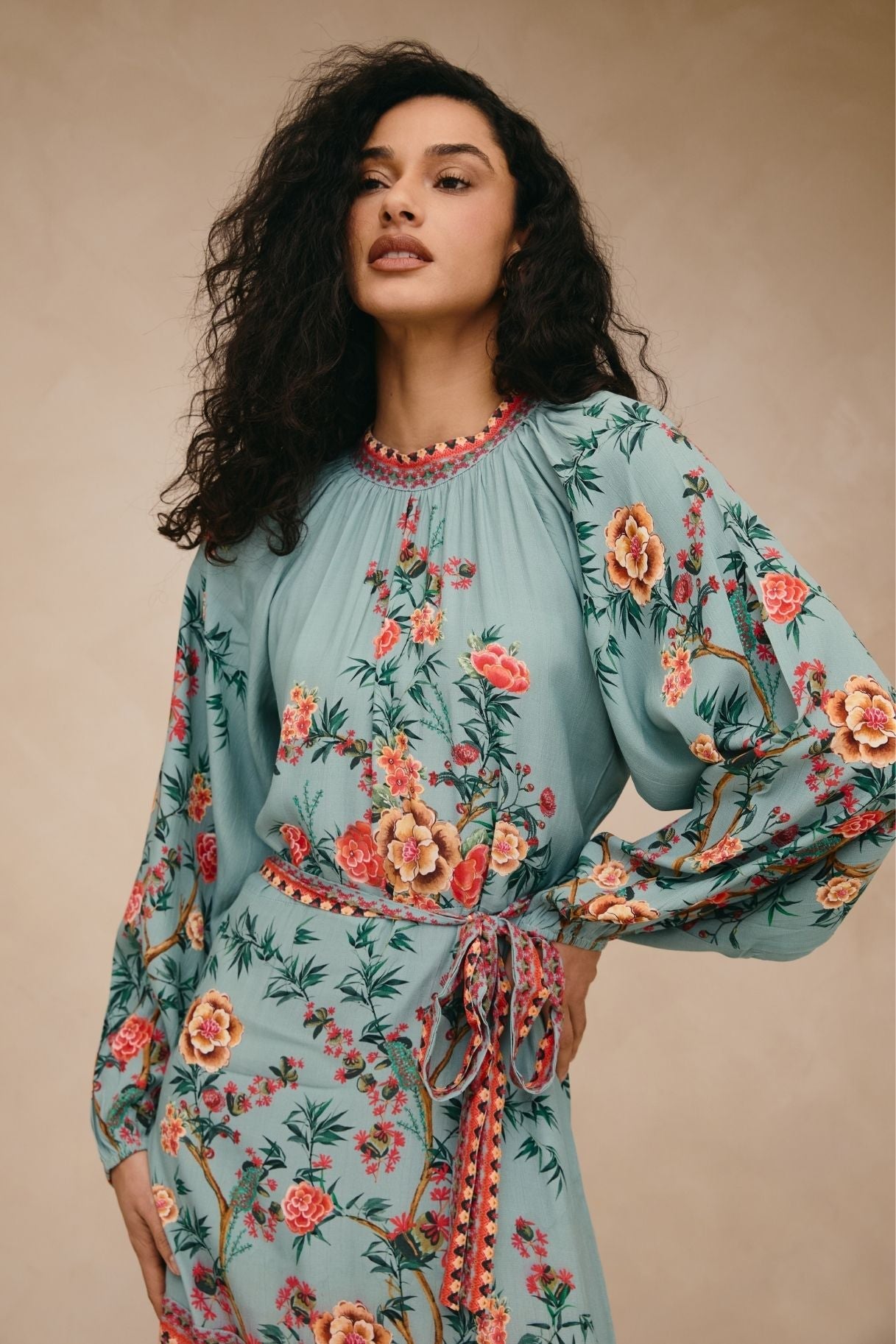 Woman wearing a floral dress with a beige background