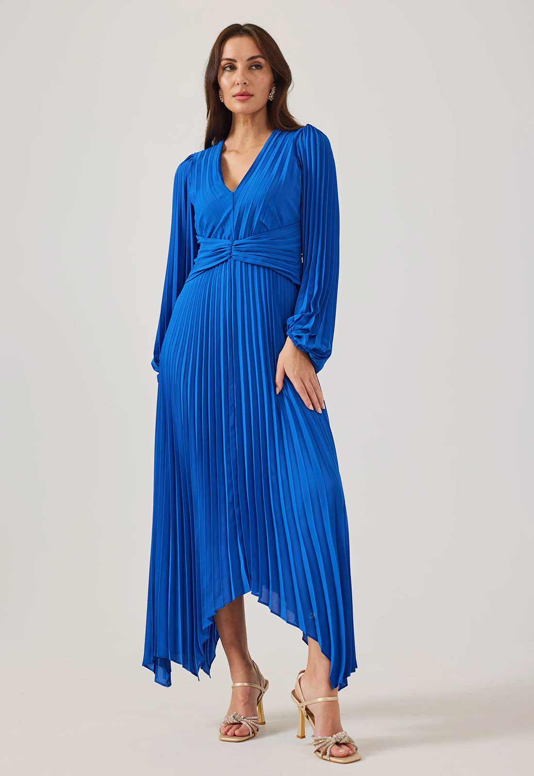 Woman wearing a blue pleated dress on a white background