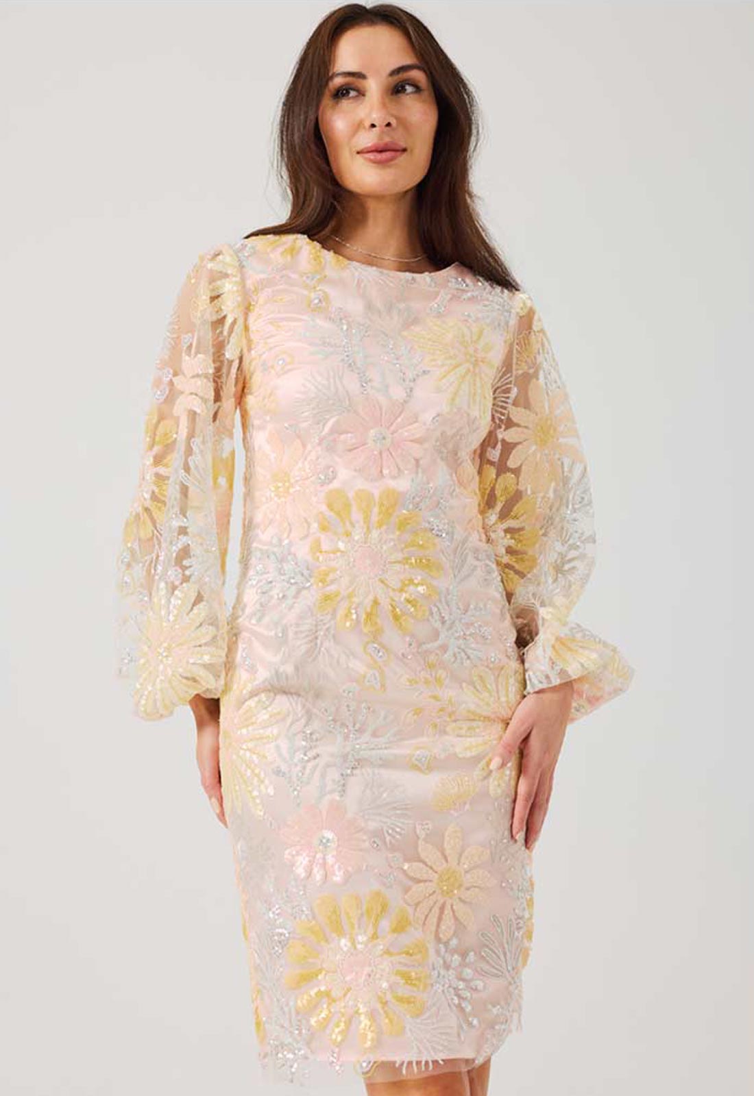 Woman wearing a floral lace dress with a plain background