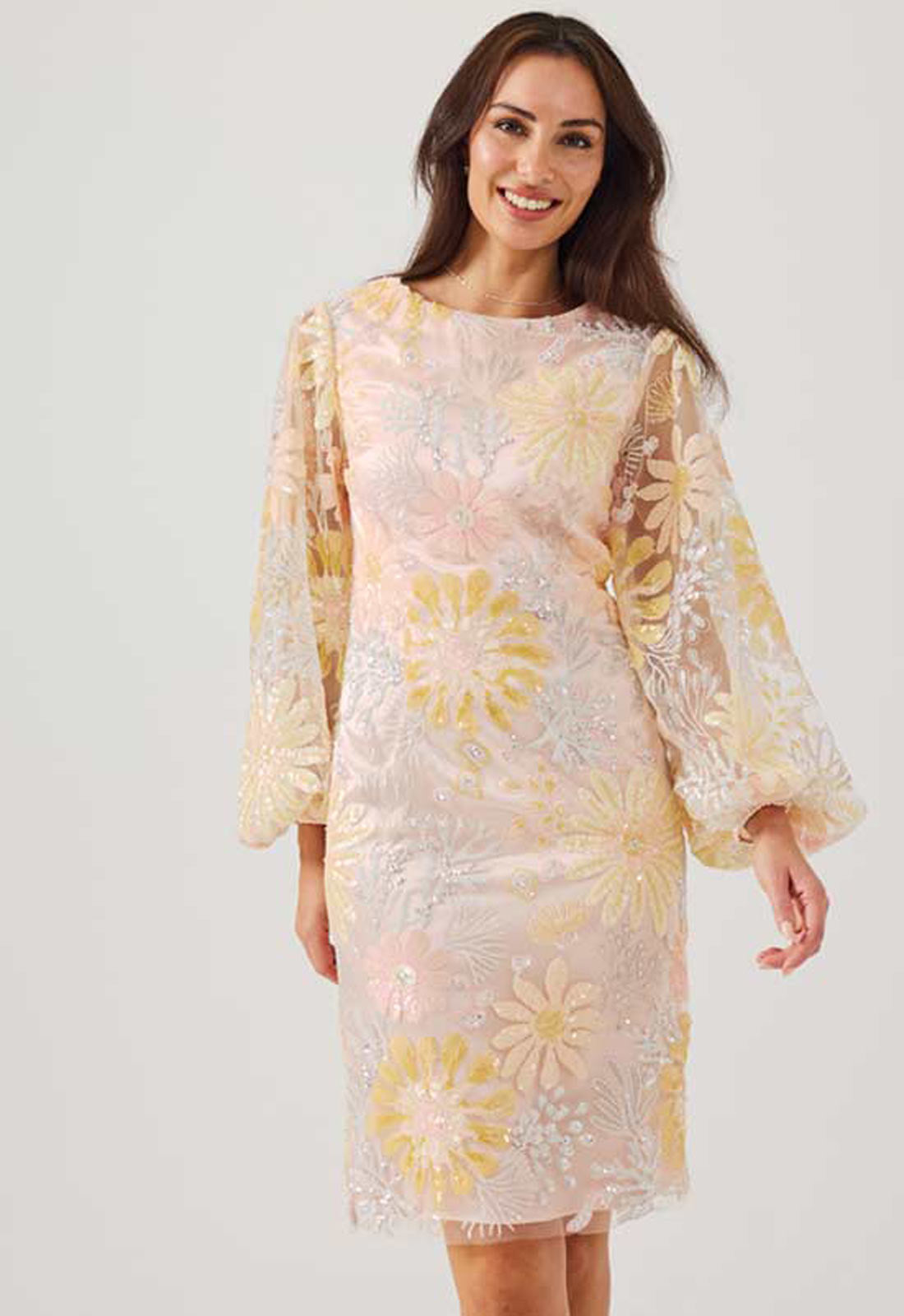 Woman wearing a floral dress with long sleeves on a white background