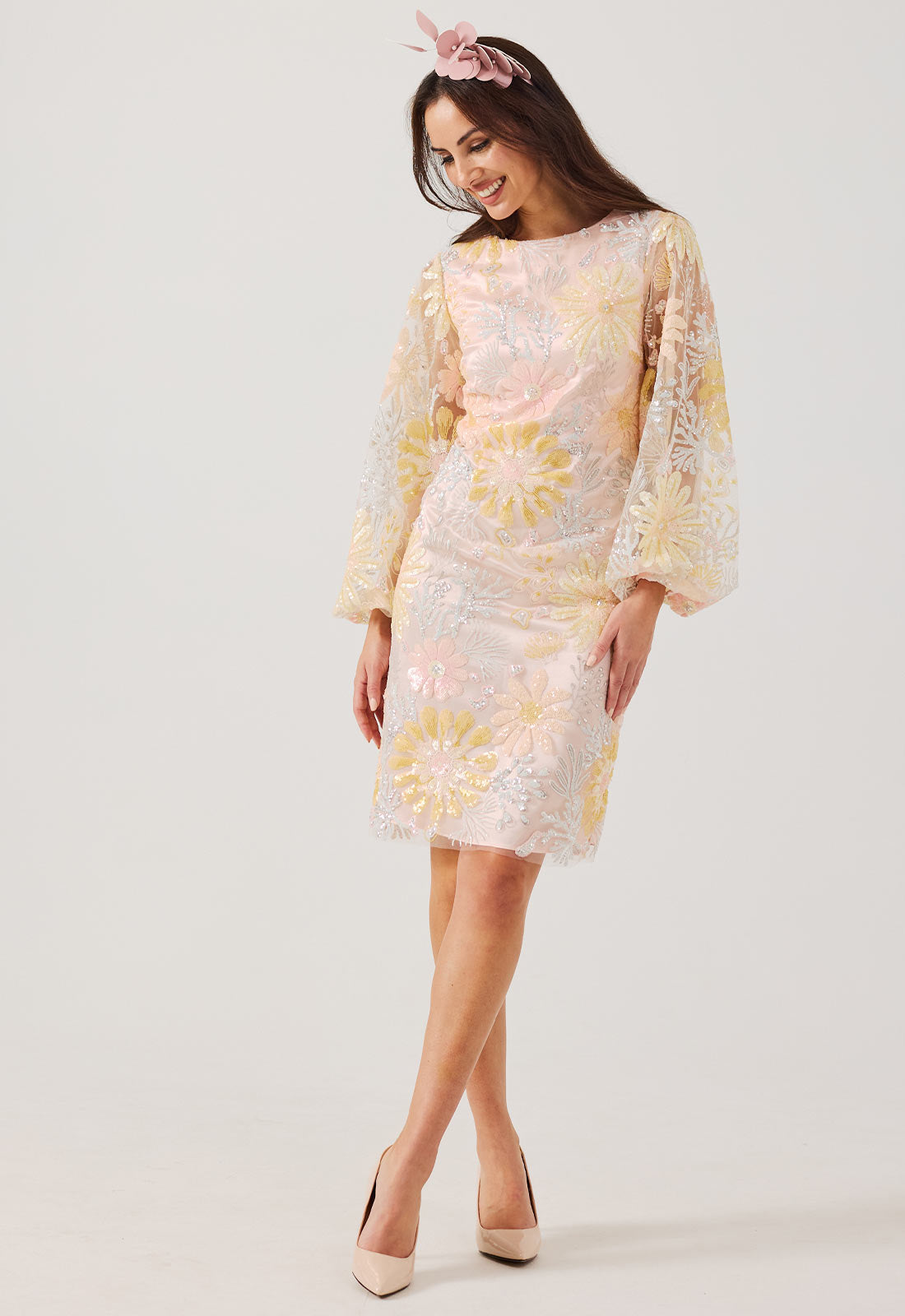 Woman wearing a floral dress with long sleeves on a white background