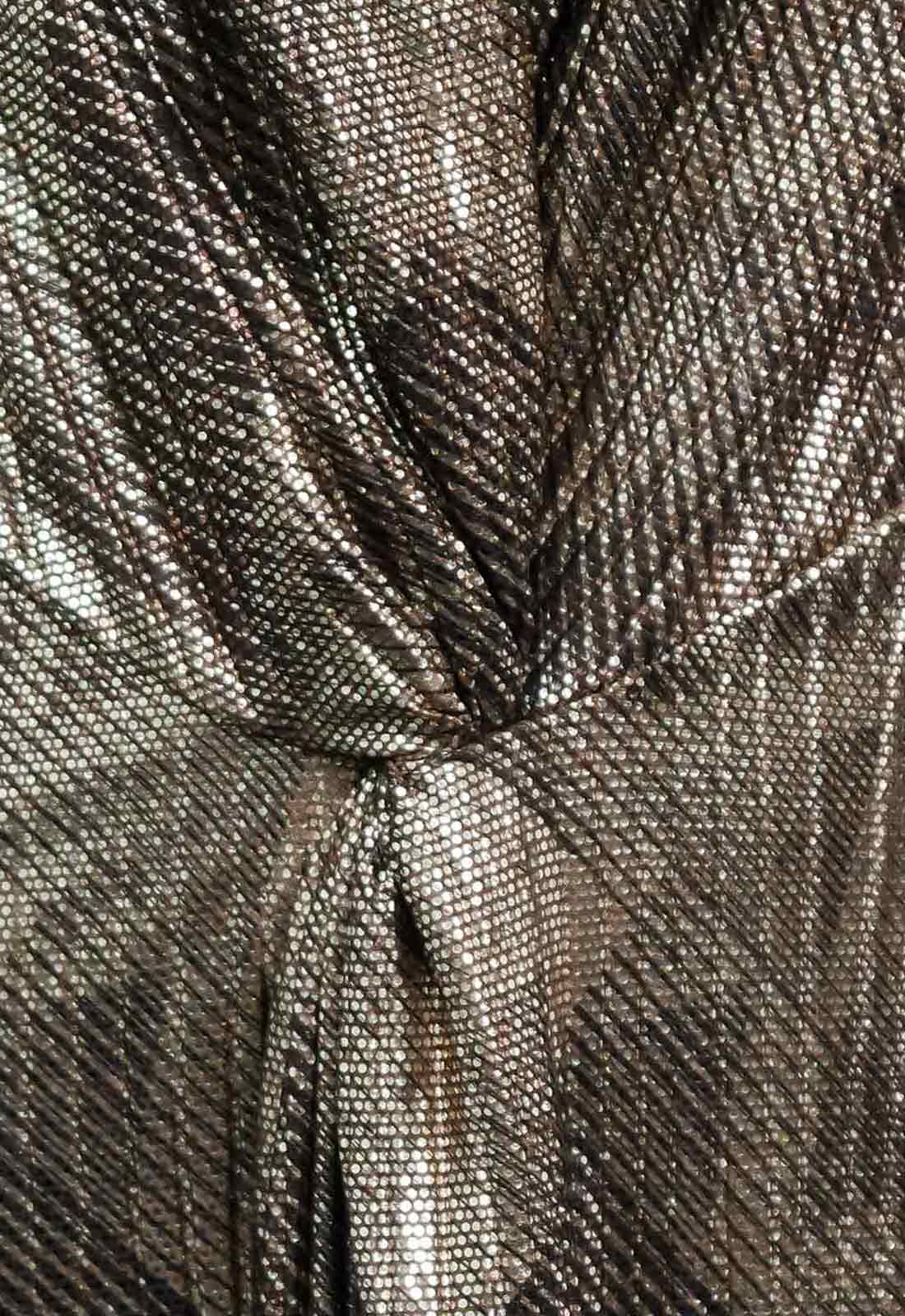 Close-up of a textured metallic fabric with a knot.