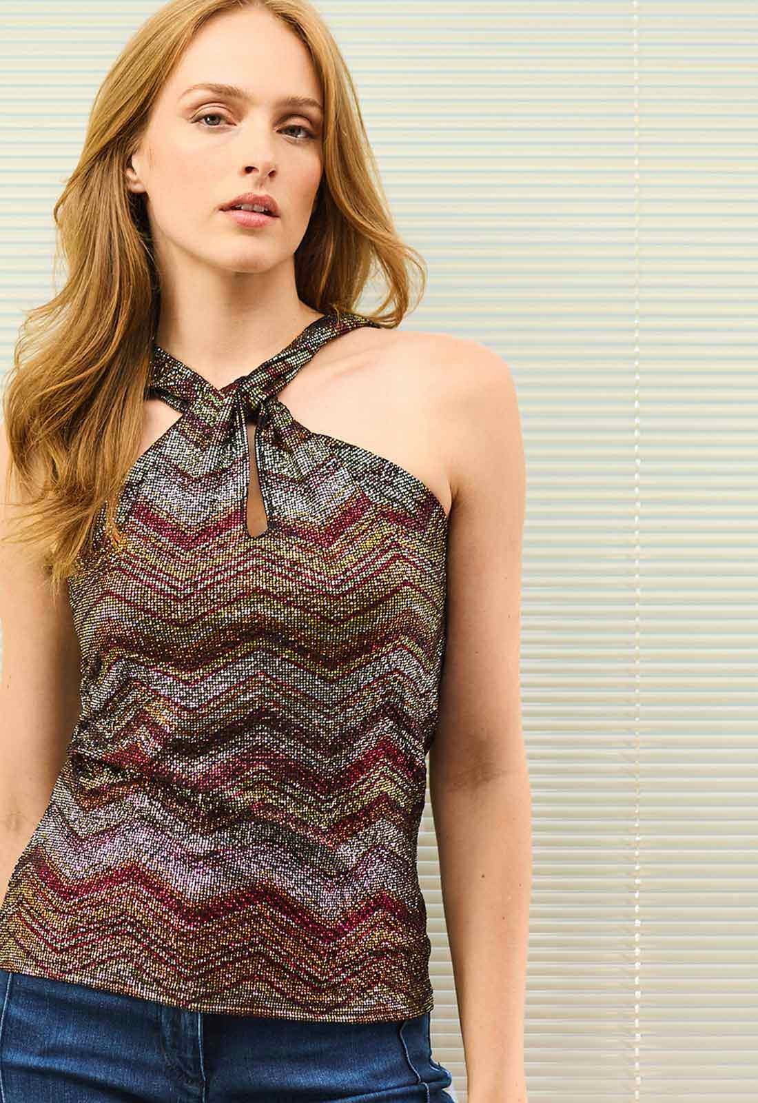 Woman wearing a patterned halter top against a neutral background