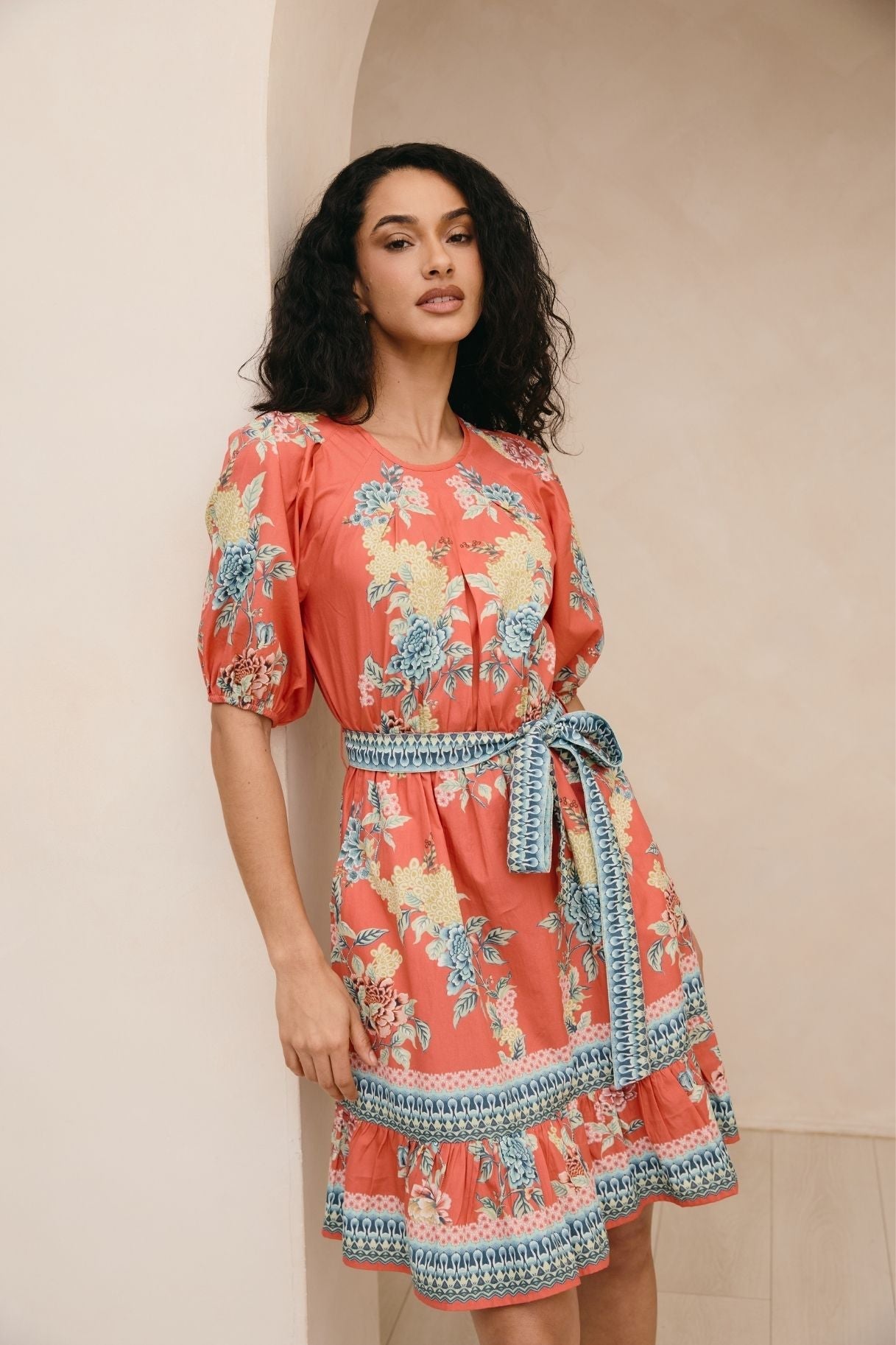 Woman wearing a floral dress with a neutral background