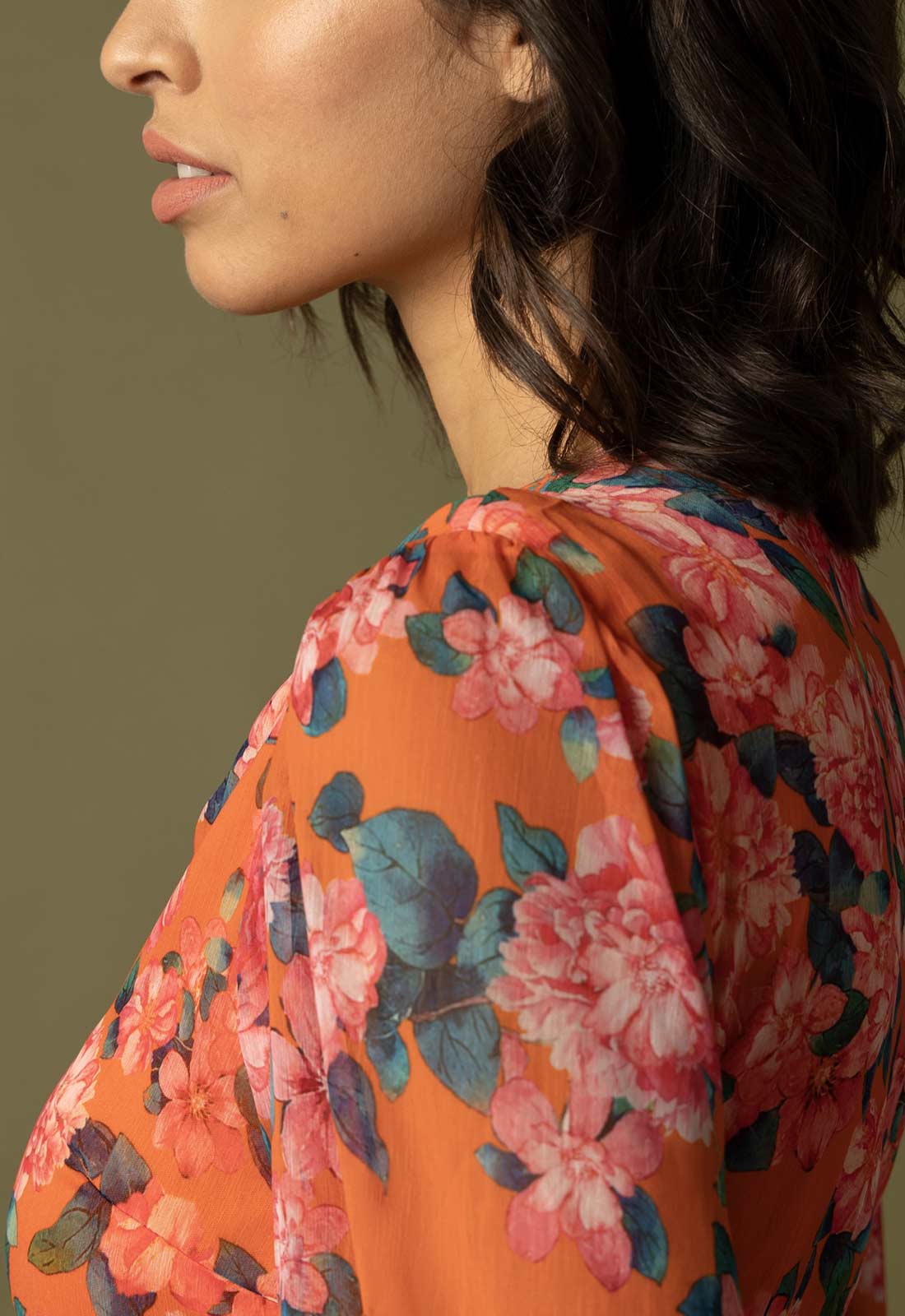 Woman wearing a floral dress with an orange background