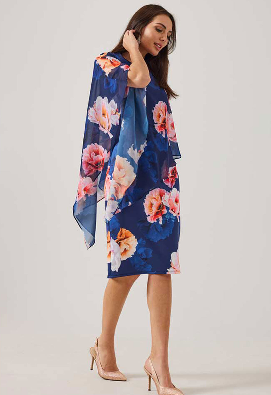Woman wearing a blue floral dress against a white background