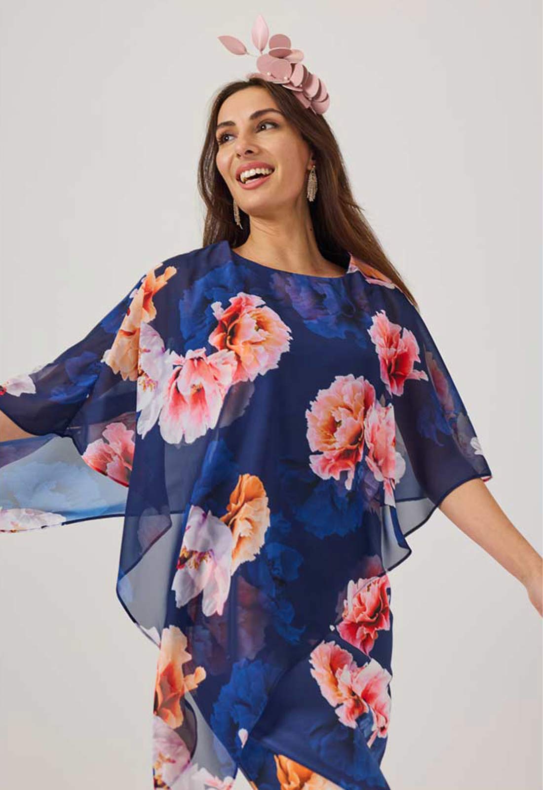 Woman wearing a navy floral dress with a white background