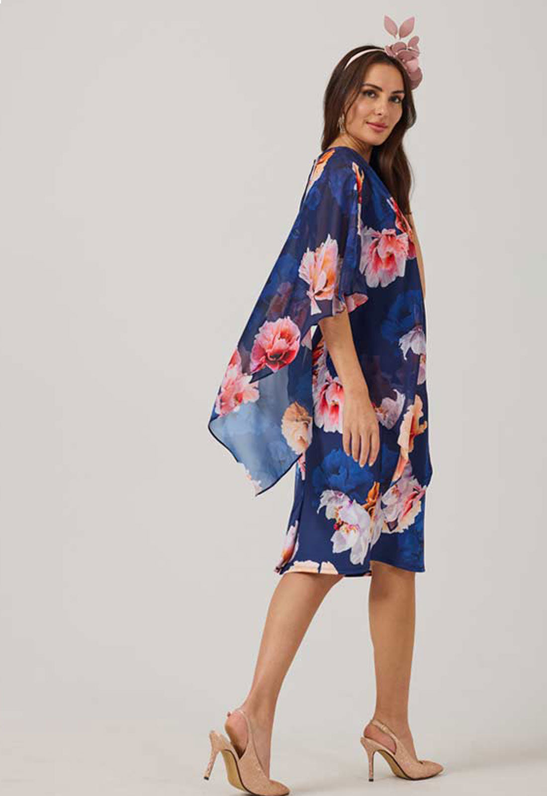 Woman wearing a blue floral dress against a white background