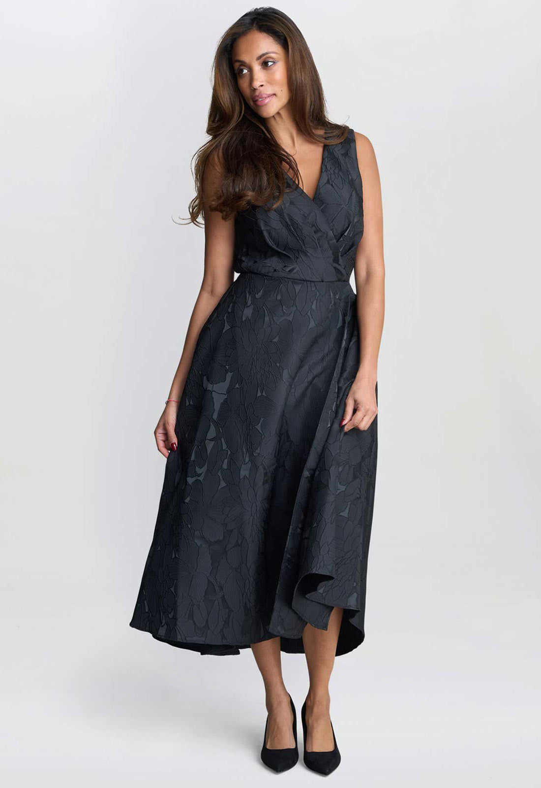 Woman wearing a black dress with floral patterns on a white background