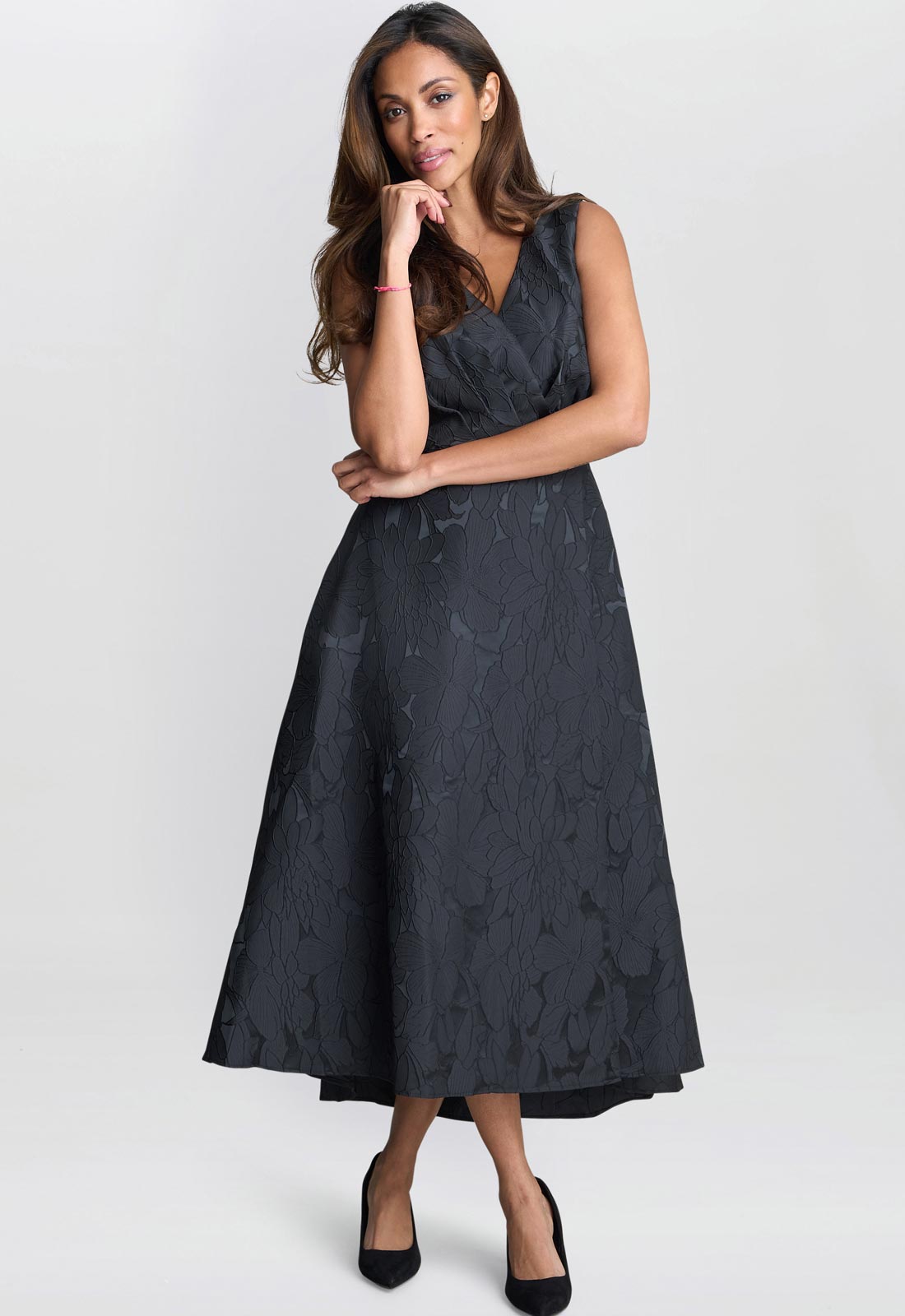 Woman wearing a black floral dress on a white background