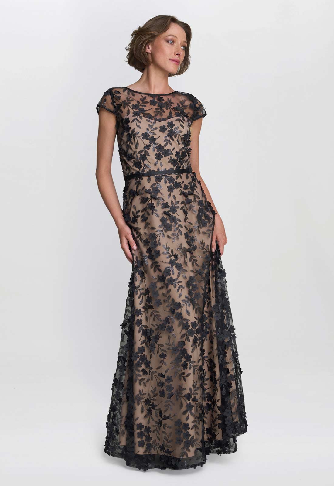 Woman wearing a black lace evening gown on a white background