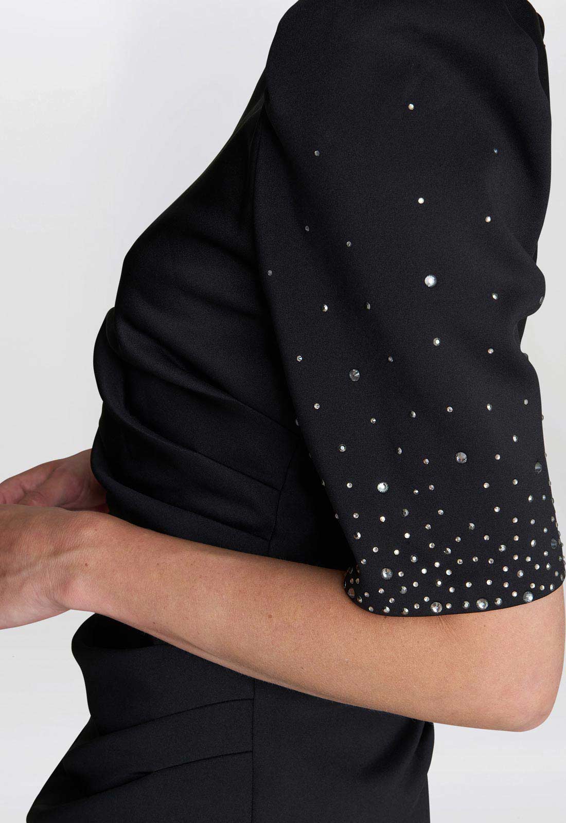 Black top with white polka dots on a plain background