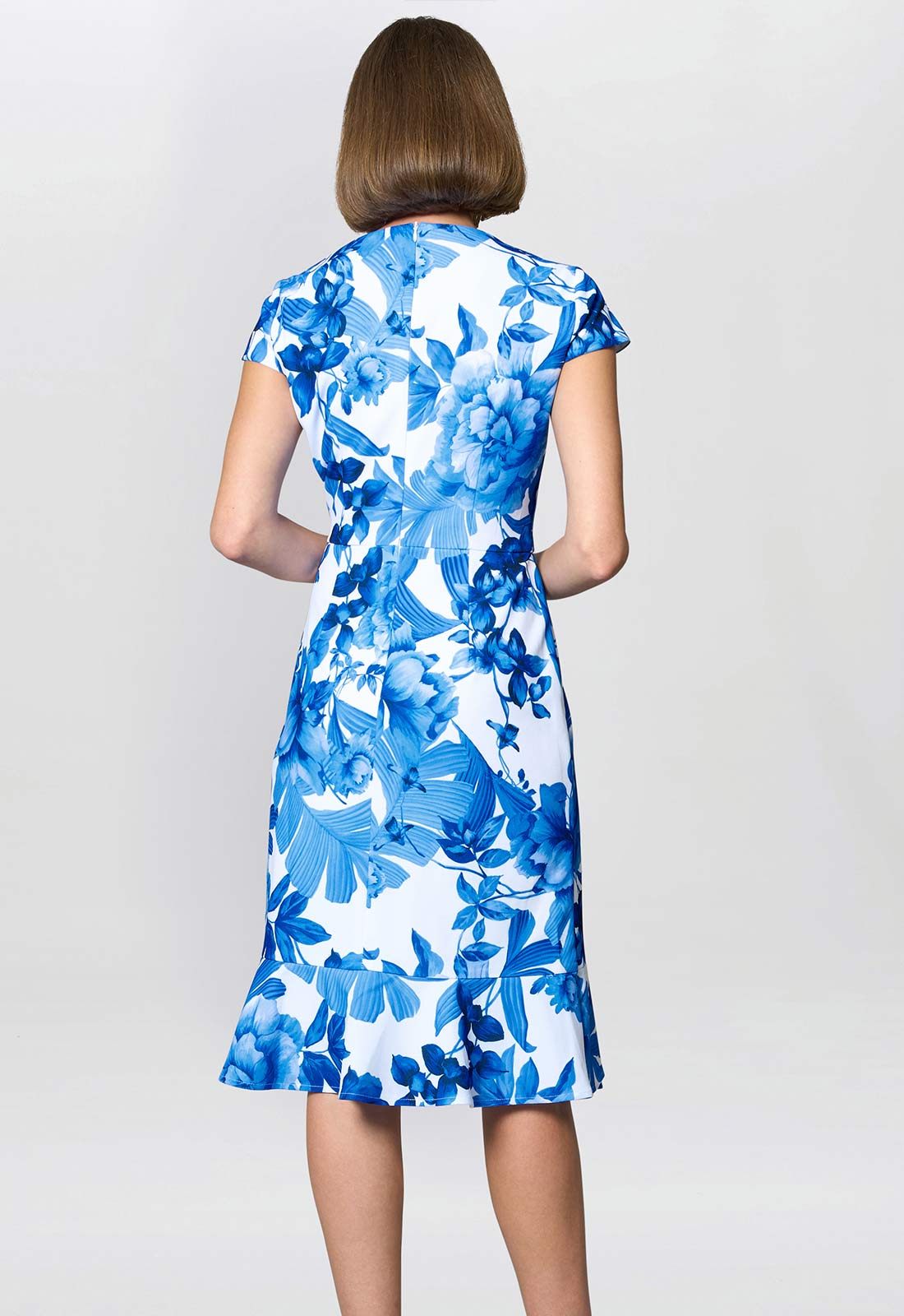 Woman wearing a blue floral dress on a white background