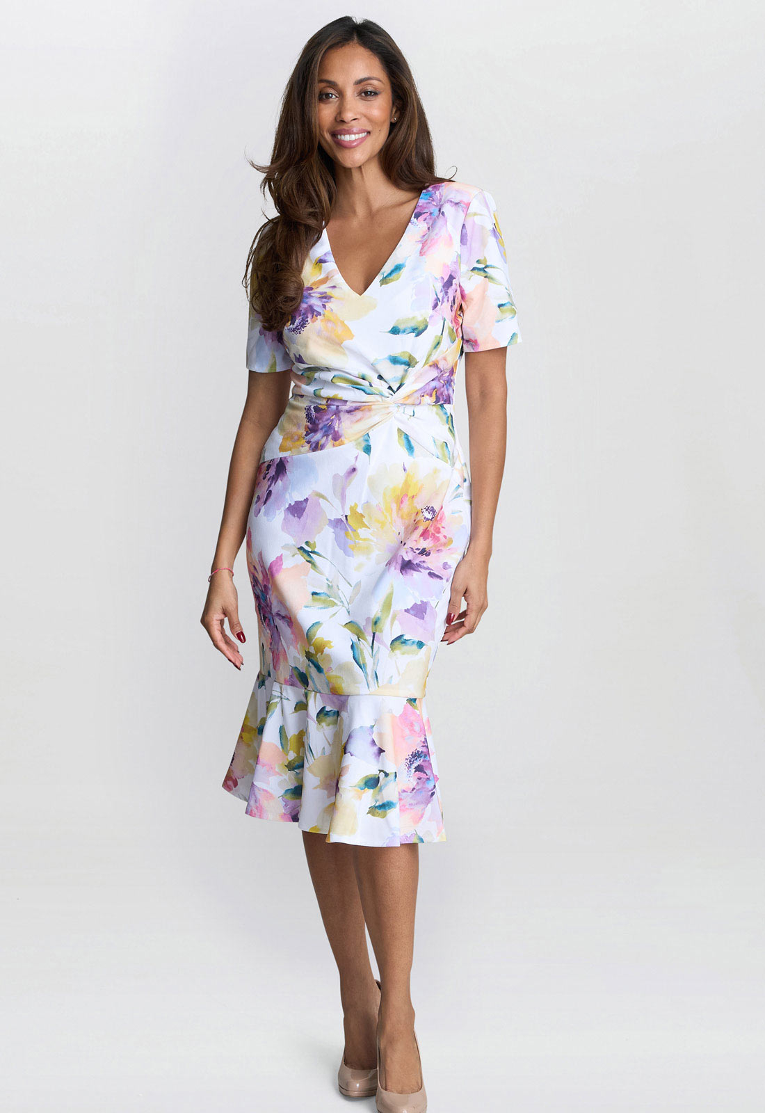 Woman wearing a floral dress against a plain background