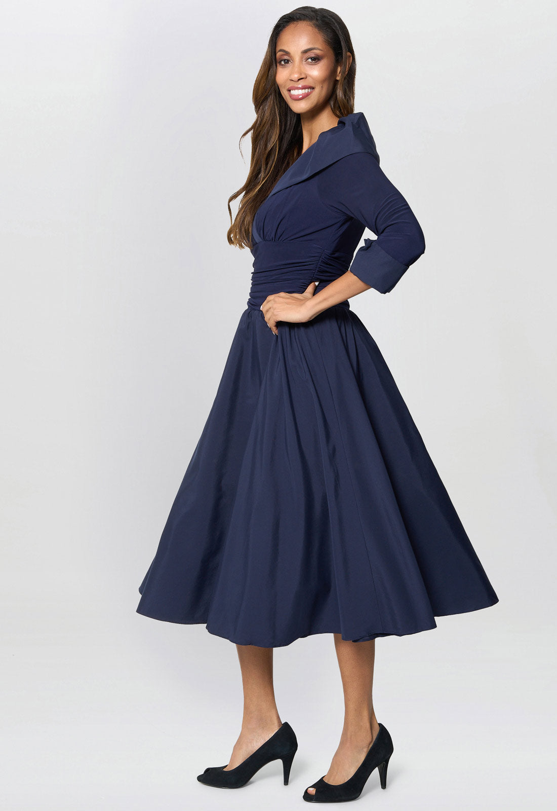 Woman wearing a navy blue dress on a white background