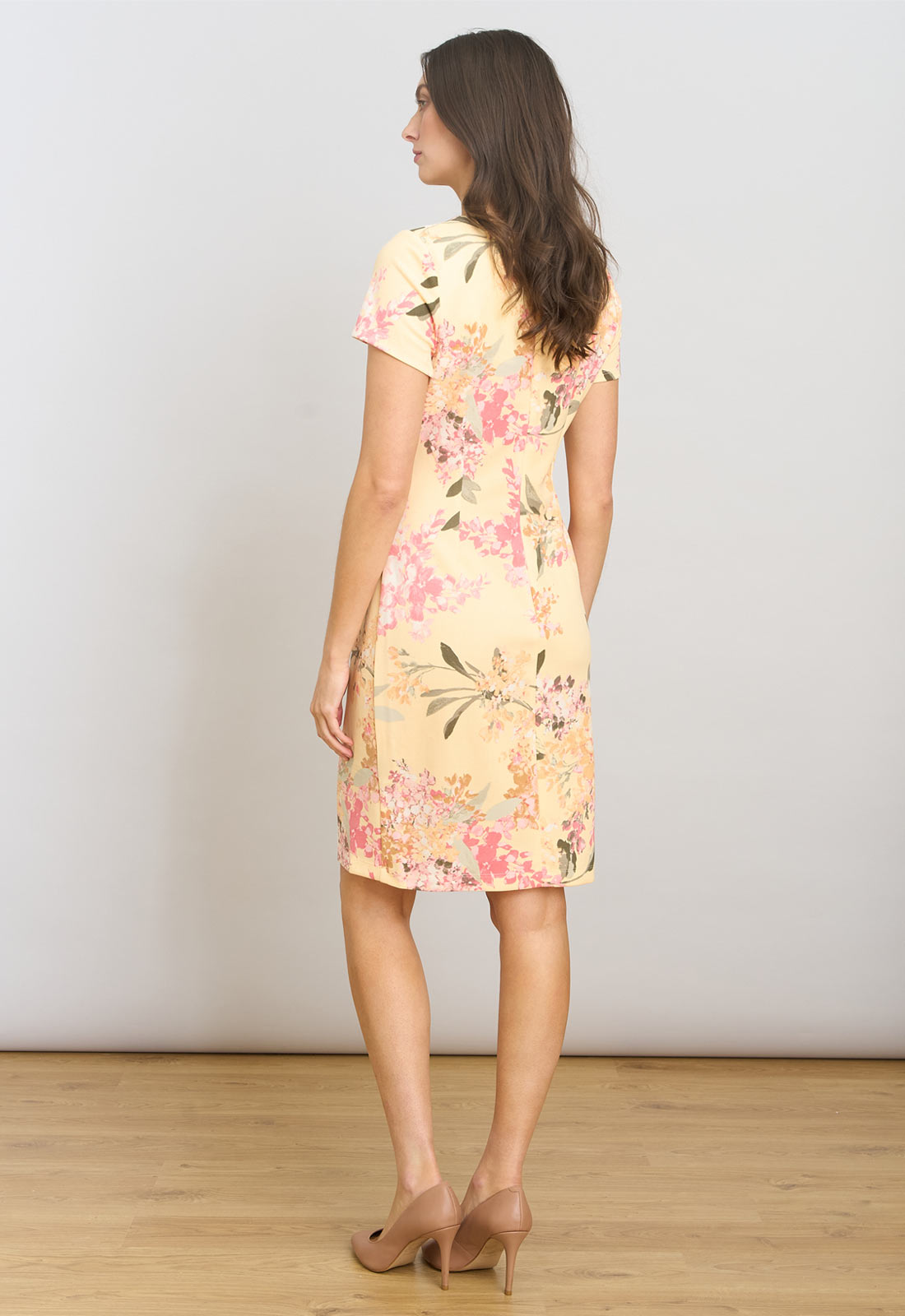 Woman wearing a floral dress against a plain background