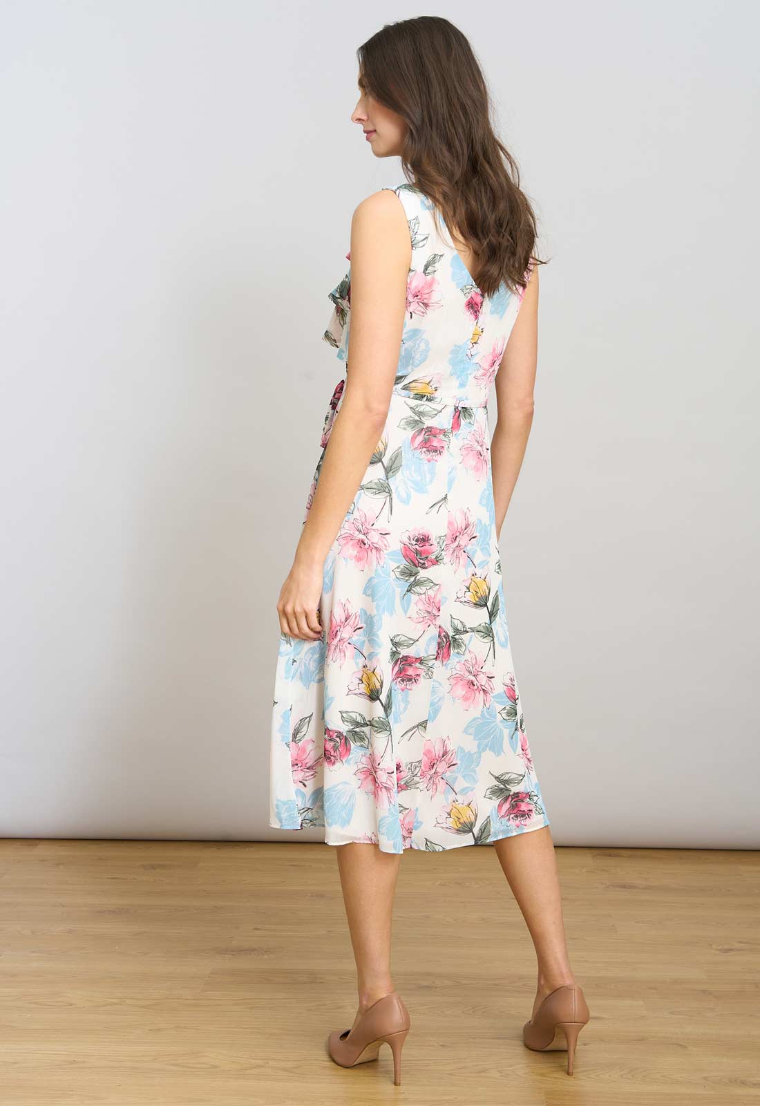 Woman wearing a floral dress against a plain background
