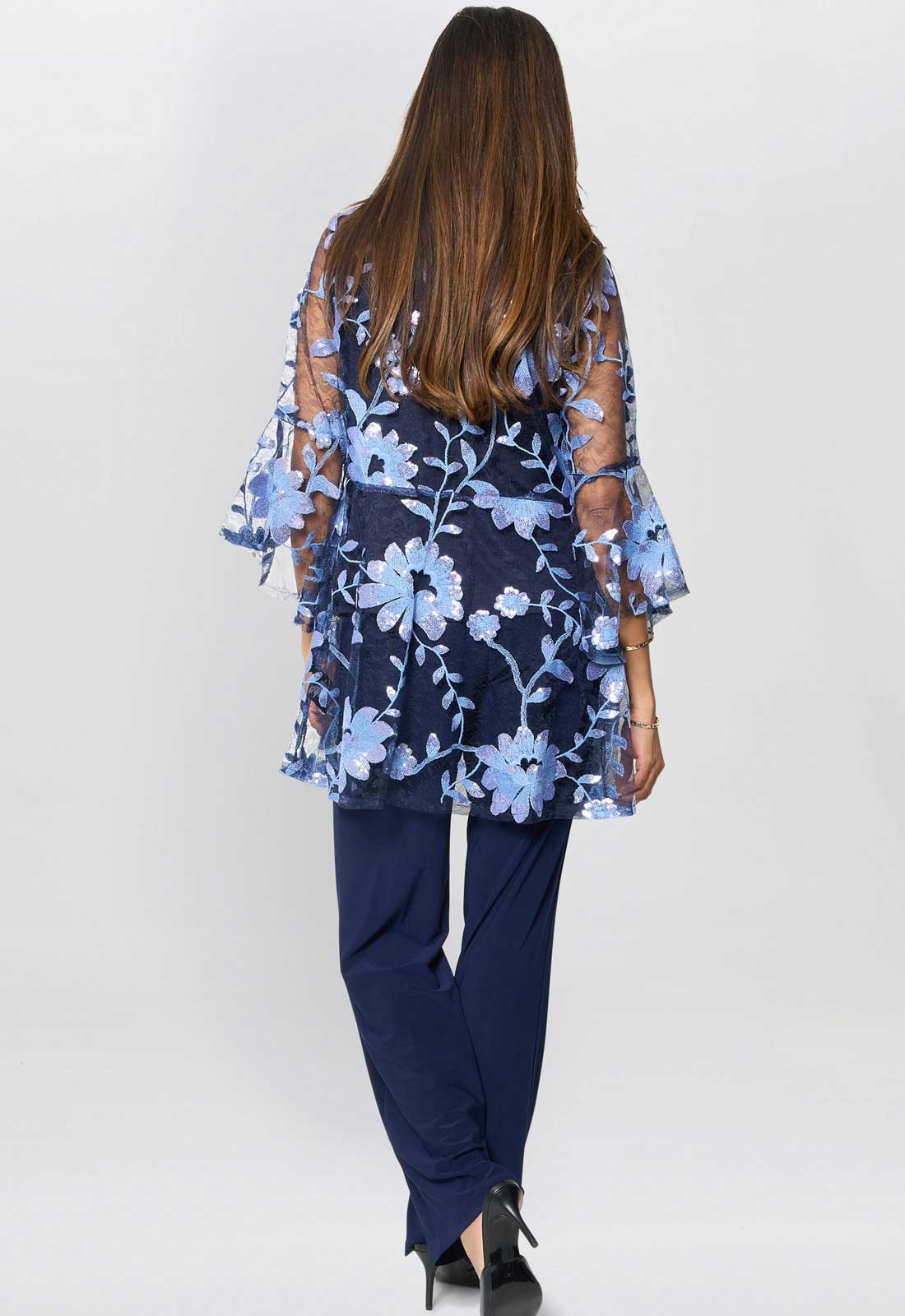 Woman wearing a navy blue outfit with floral embroidery on a white background