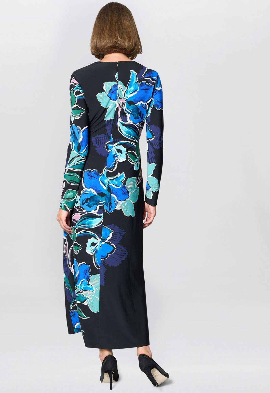 Woman wearing a black dress with blue floral pattern on a white background