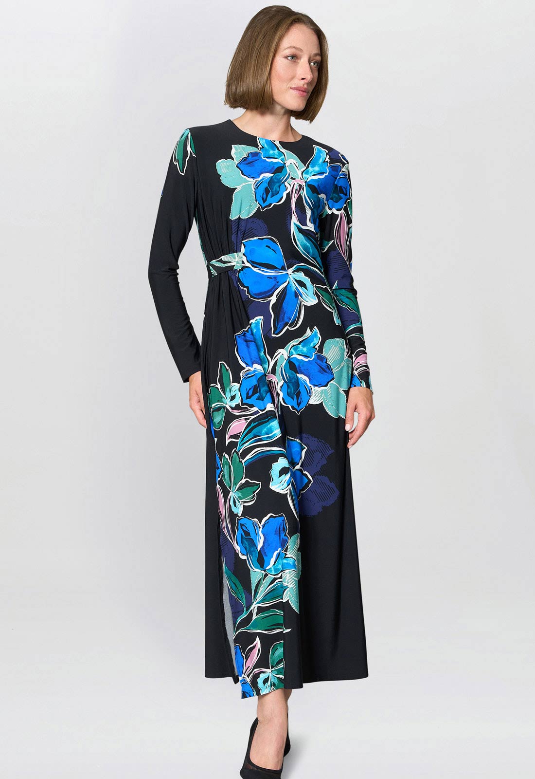 Woman wearing a black dress with blue floral pattern on a white background