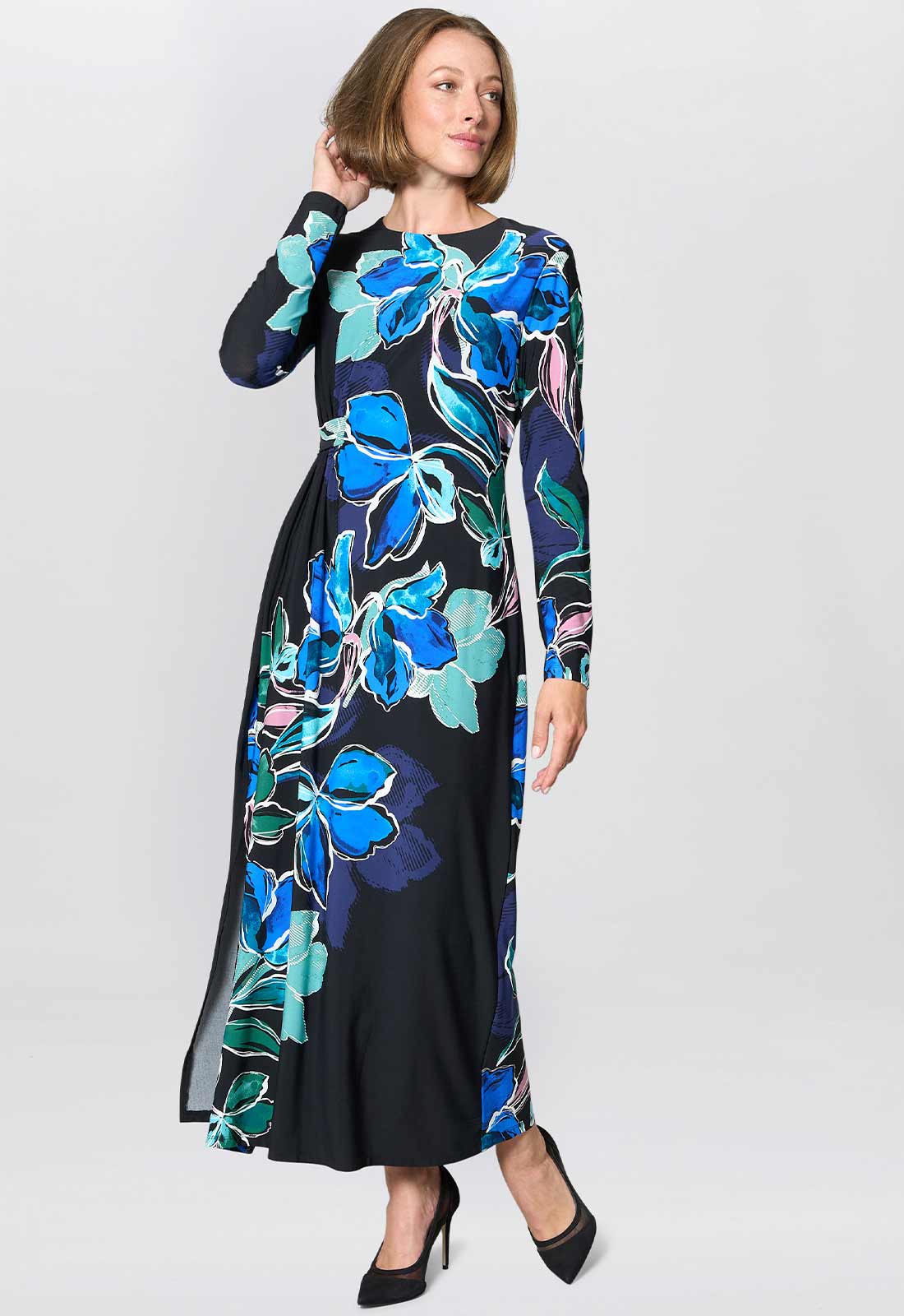 Woman wearing a black dress with blue floral pattern on a white background