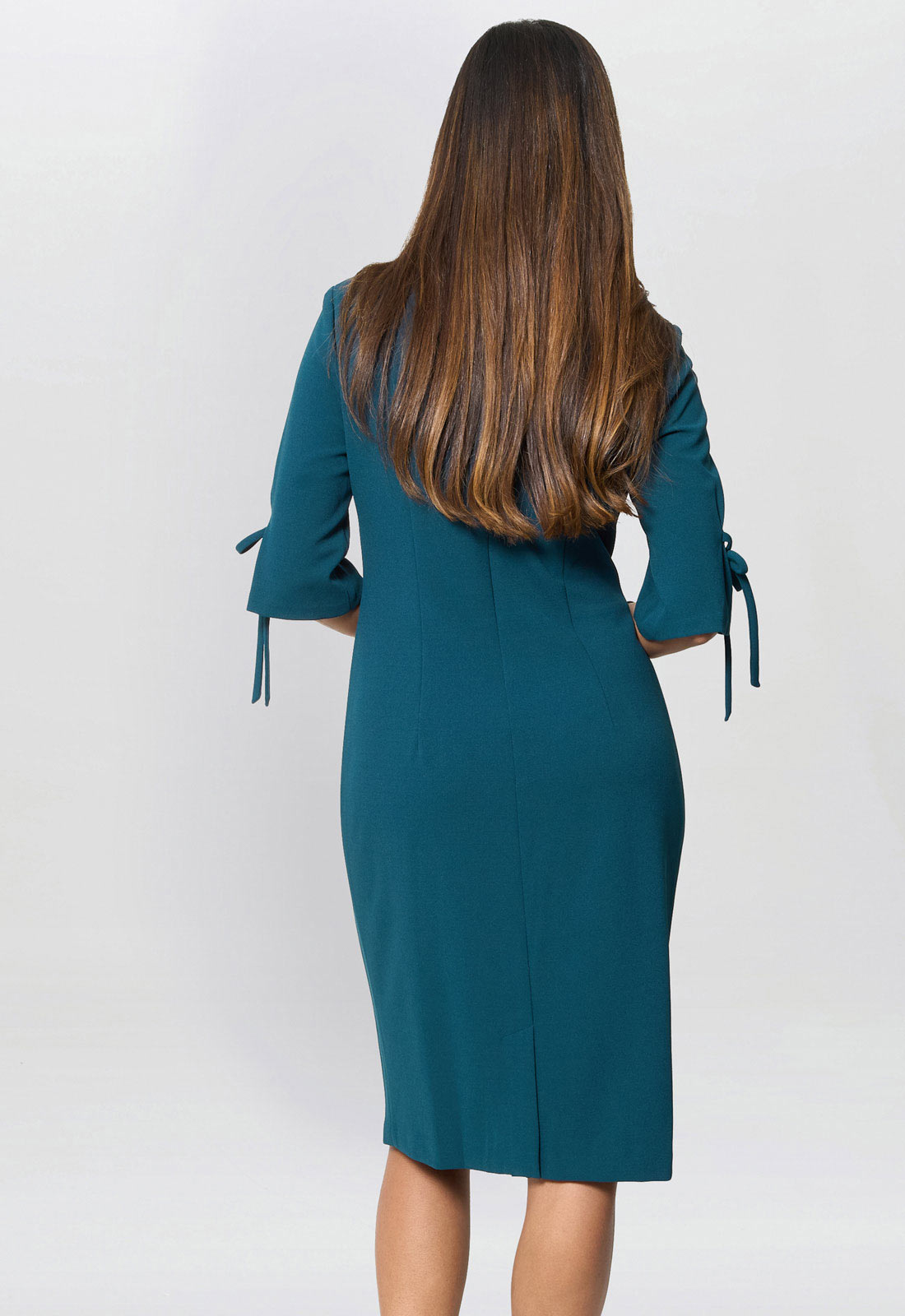 Teal dress with bow details on a white background