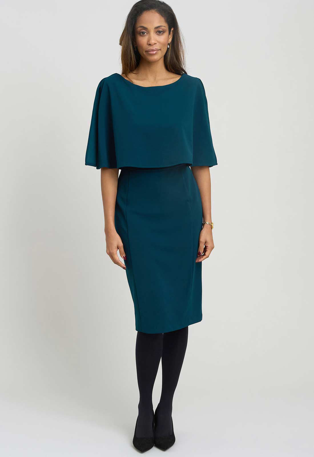 Woman wearing a teal dress with a white background