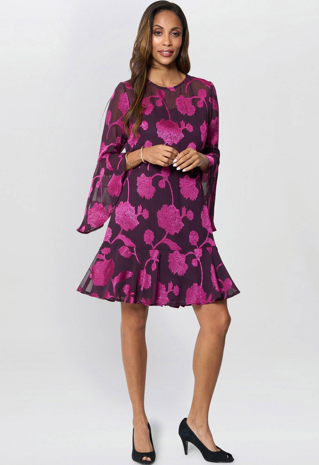 Woman wearing a purple floral dress on a white background