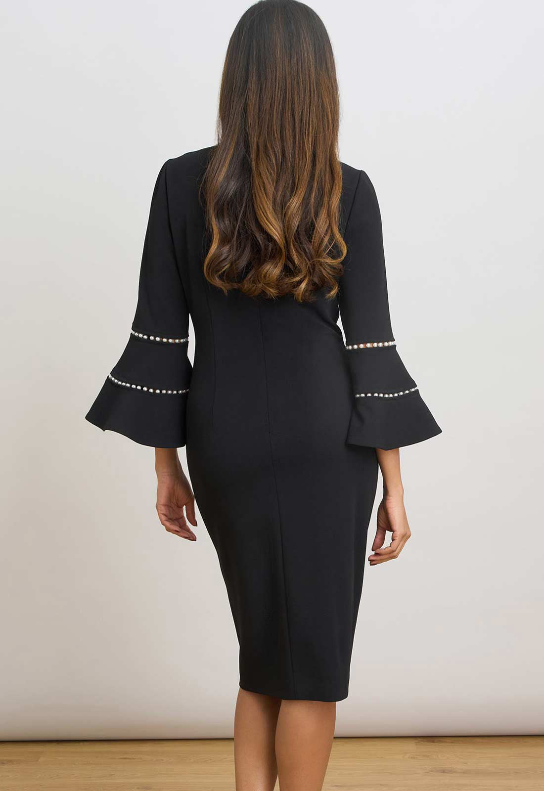 Black dress with bell sleeves on a plain background