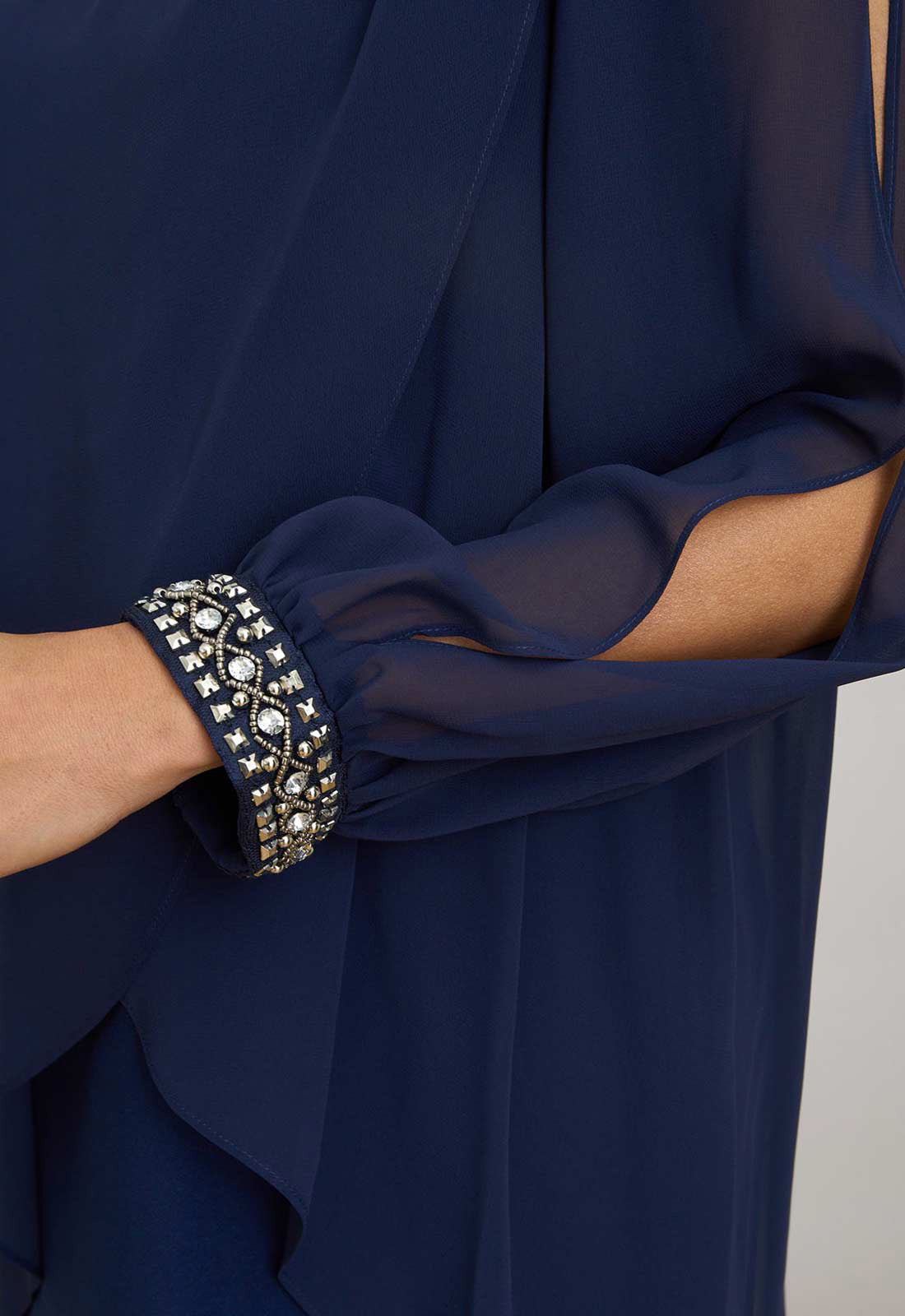 Navy blue dress with embellished cuffs on a plain background