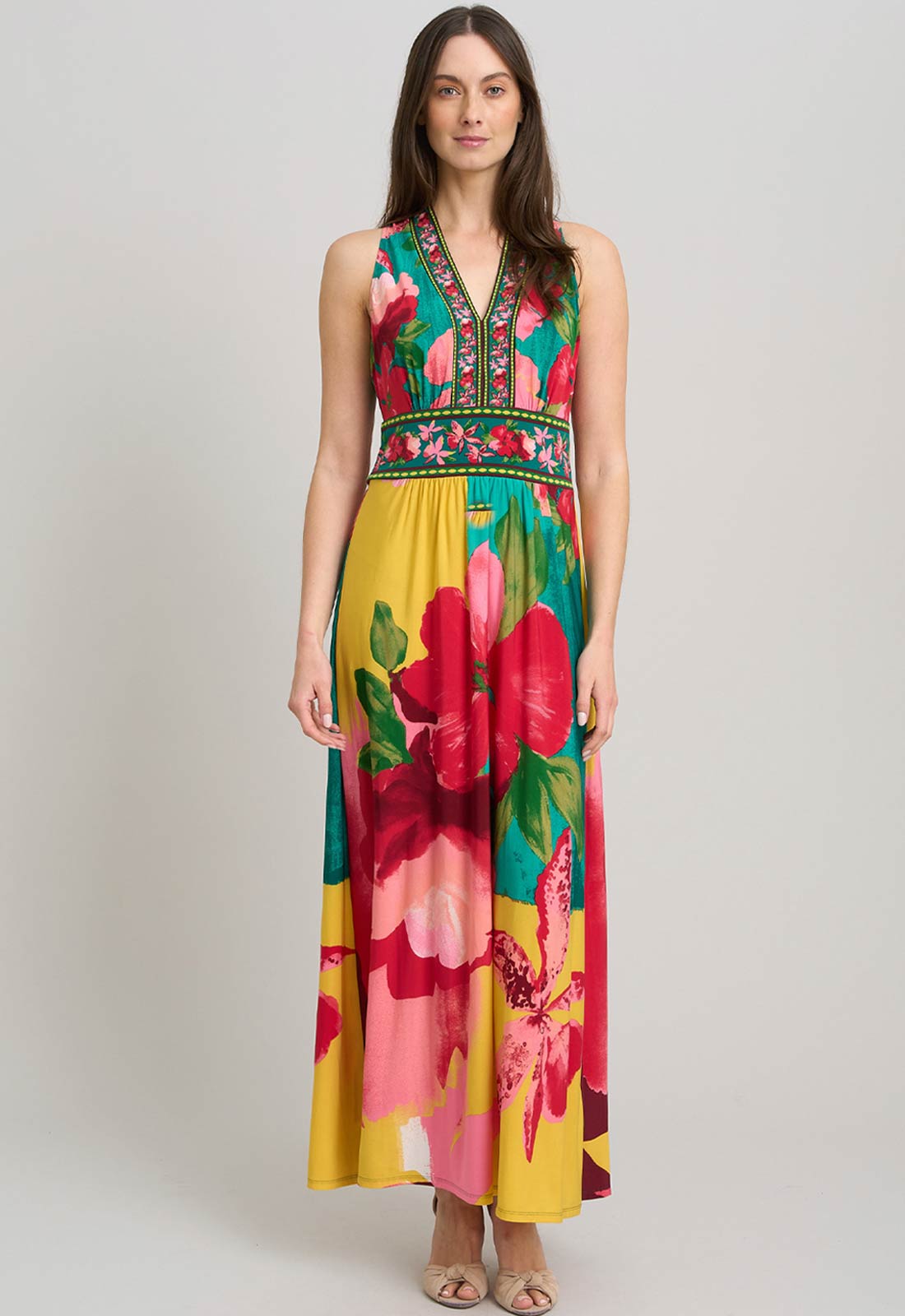 Woman wearing a colorful floral dress on a gray background