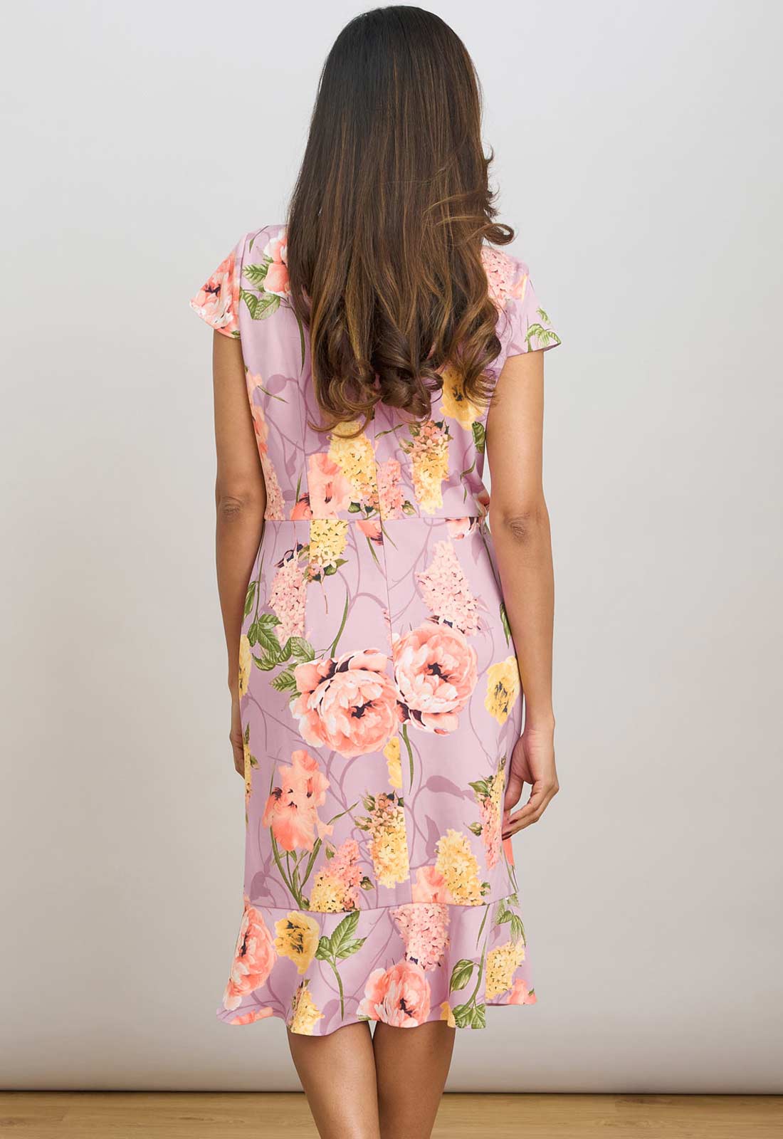 Woman wearing a floral dress with a plain background