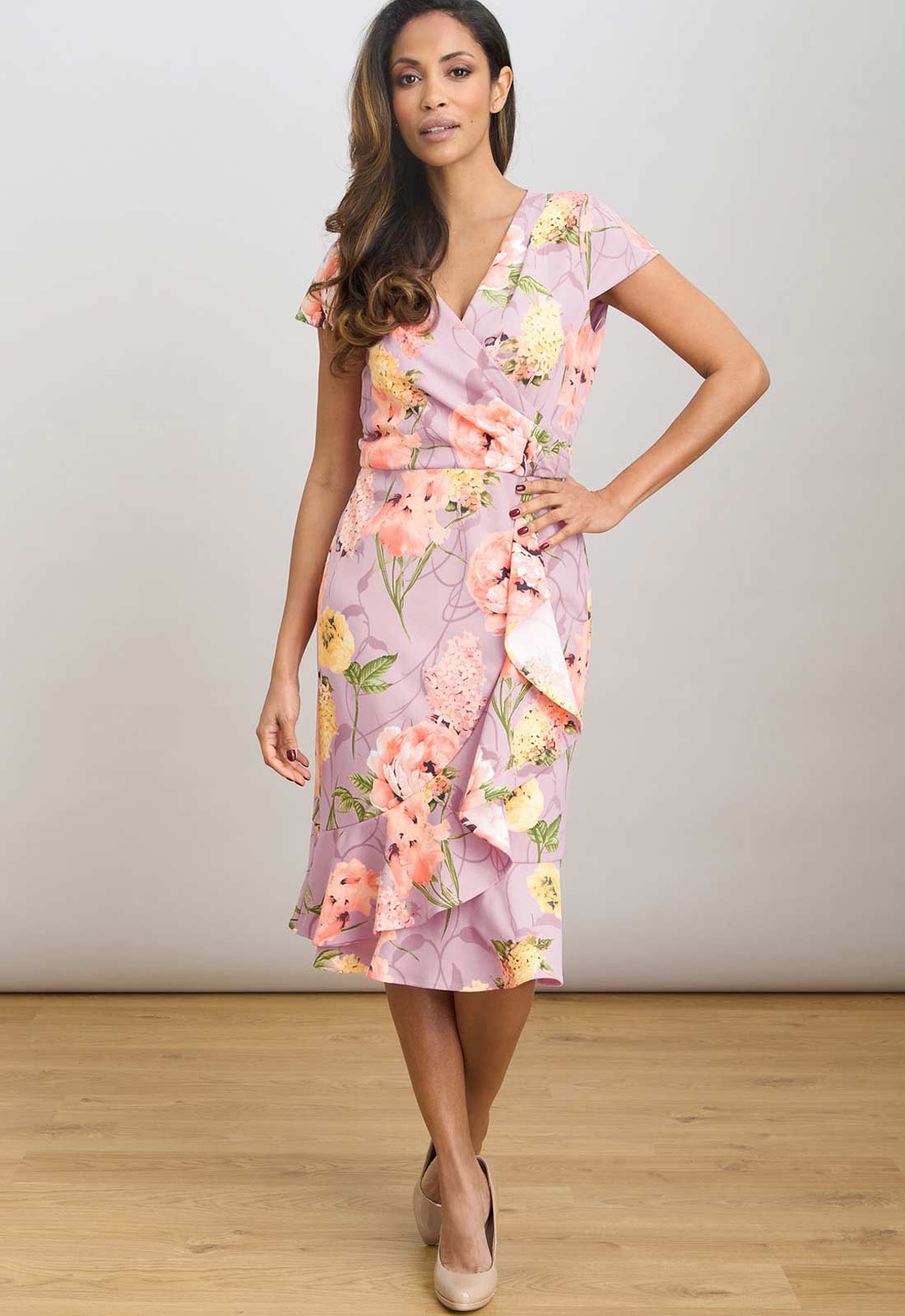 Woman wearing a floral dress with a plain background