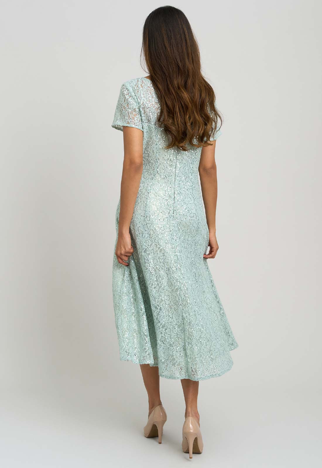 Woman wearing a light blue lace dress on a white background