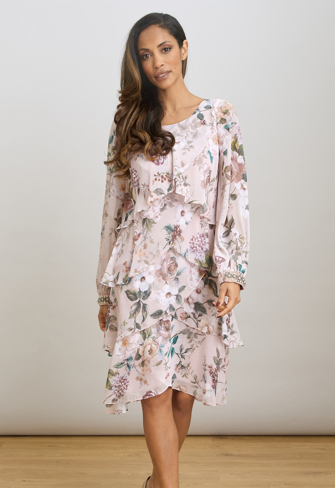 Woman wearing a floral dress against a plain background