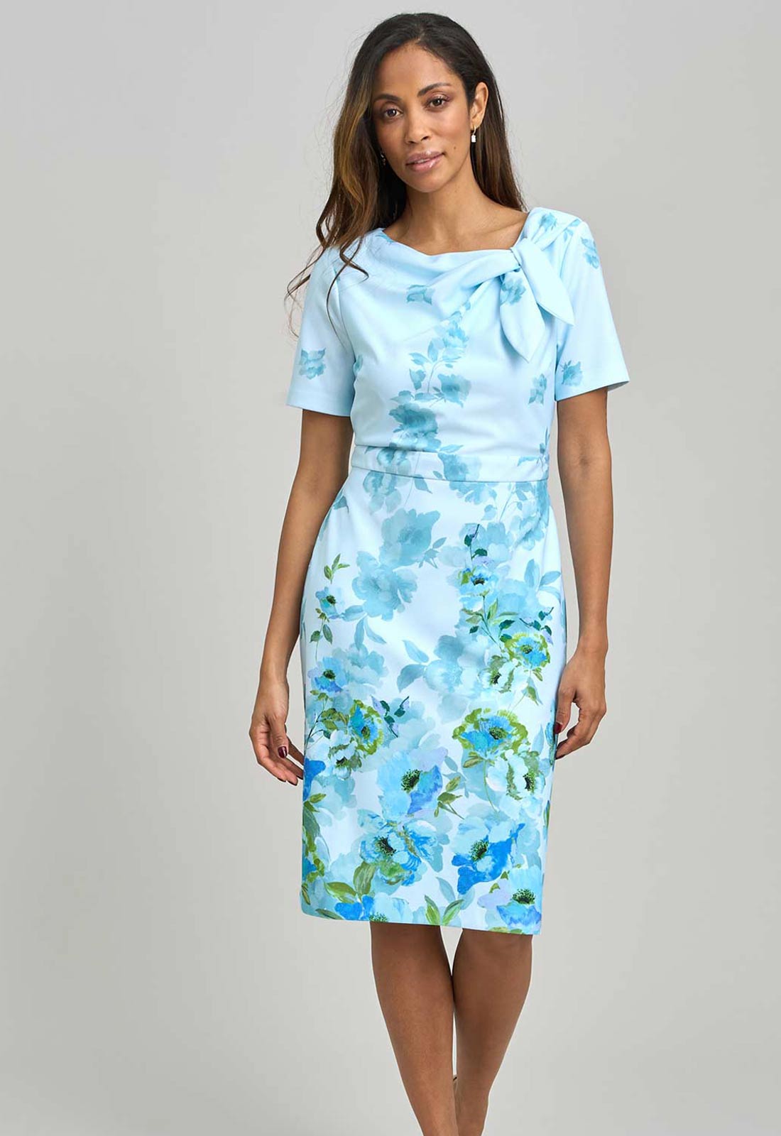 Woman wearing a light blue floral dress against a gray background
