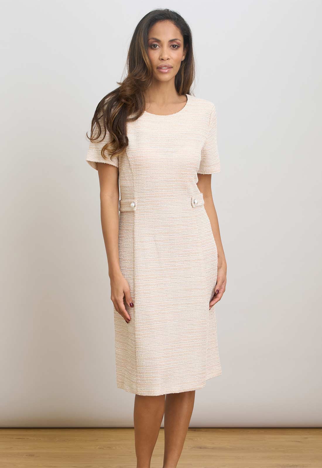 Woman wearing a pink dress with a plain background