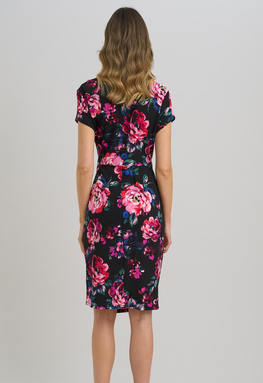 Woman wearing a floral dress on a plain background